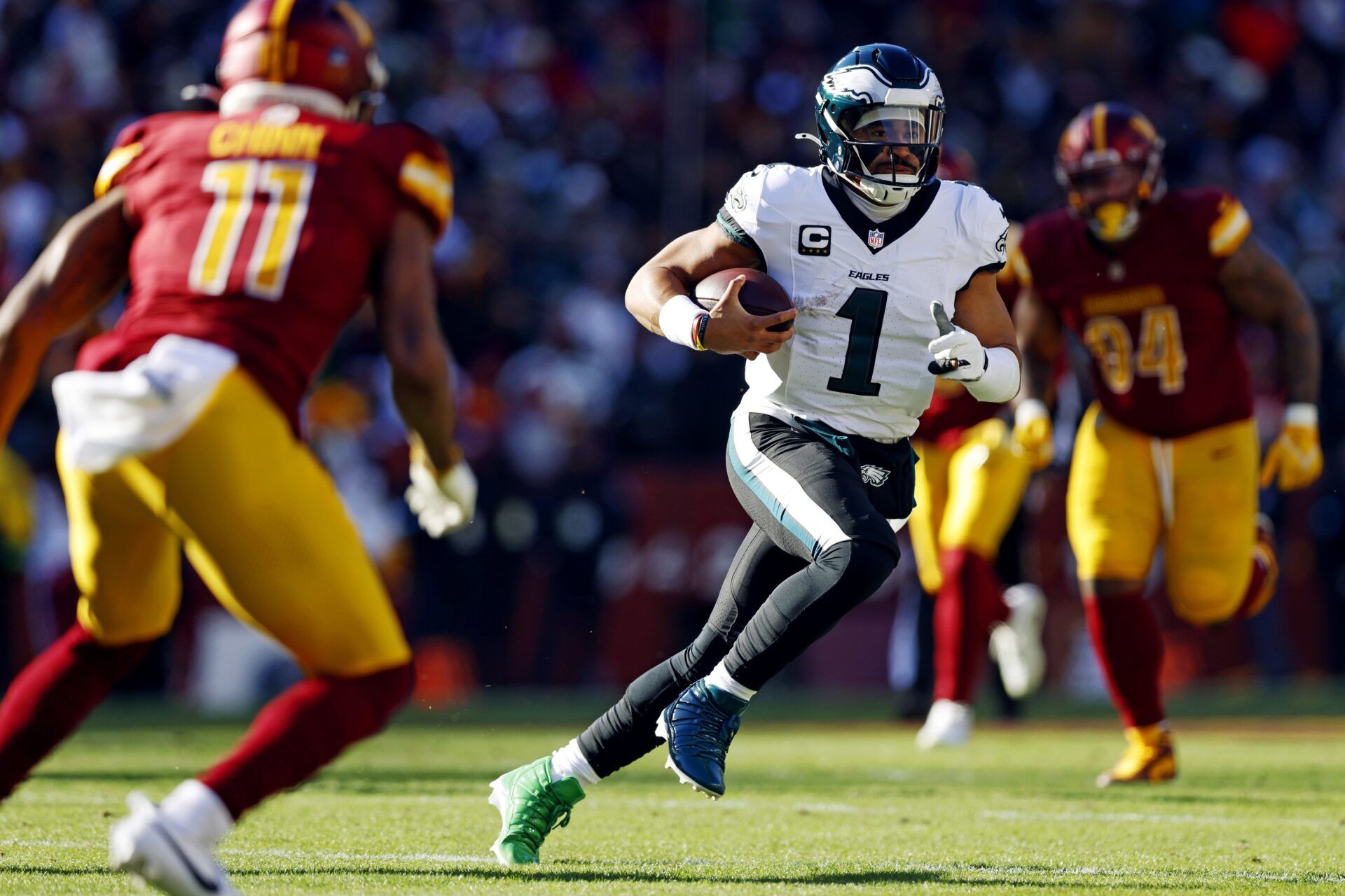 Philadelphia Eagles quarterback Jalen Hurts (1) against Washington Commanders safety Jeremy Chinn (11) during the first quarter at Northwest Stadium.