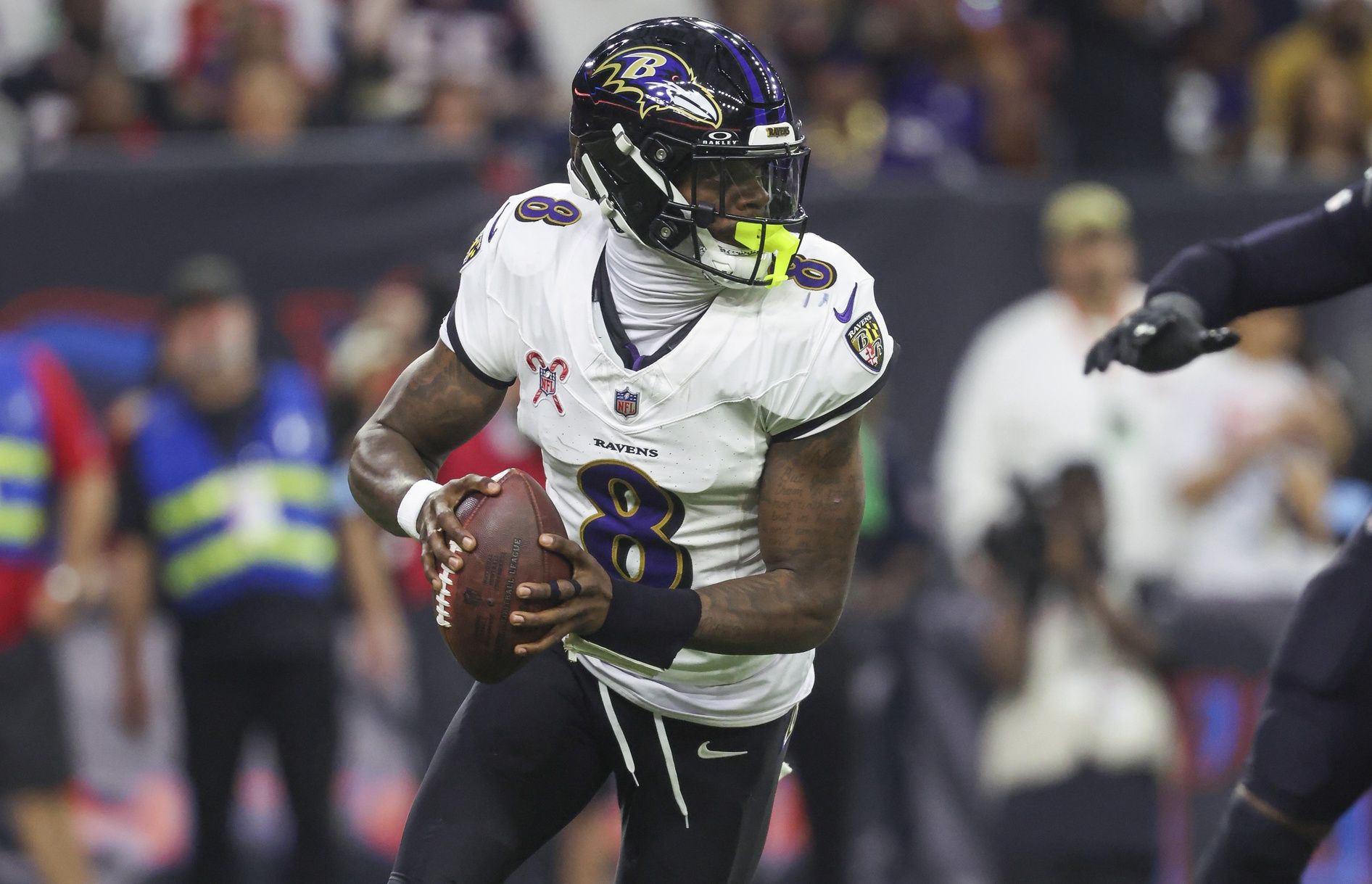 Baltimore Ravens quarterback Lamar Jackson (8) rolls out of the pocket with the ball during the game against the Houston Texans at NRG Stadium.