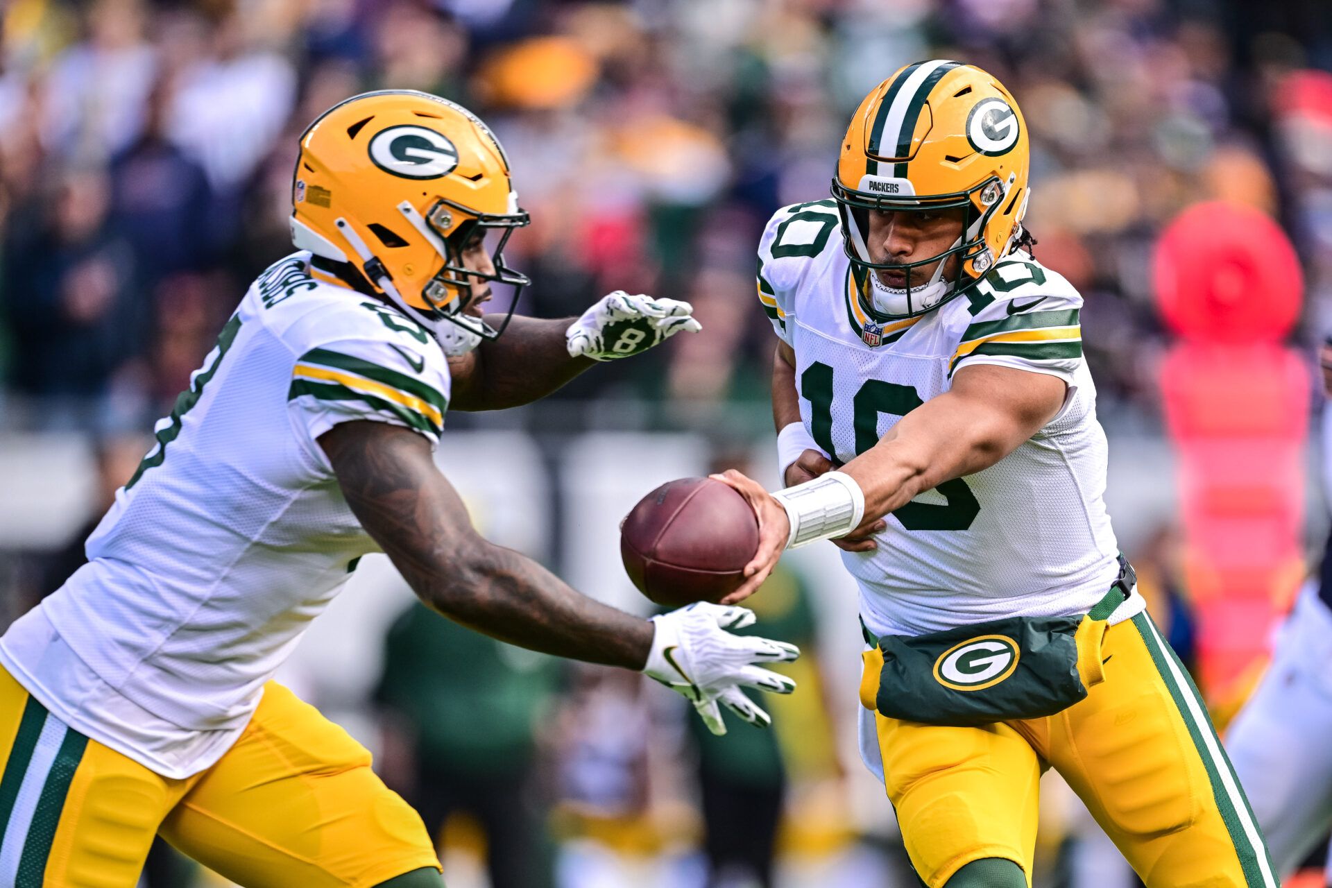 Nov 17, 2024; Chicago, Illinois, USA; Green Bay Packers quarterback Jordan Love (10) hands off the running back Josh Jacobs (8) against the Chicago Bears during the first quarter at Soldier Field. Mandatory Credit: Daniel Bartel-Imagn Images