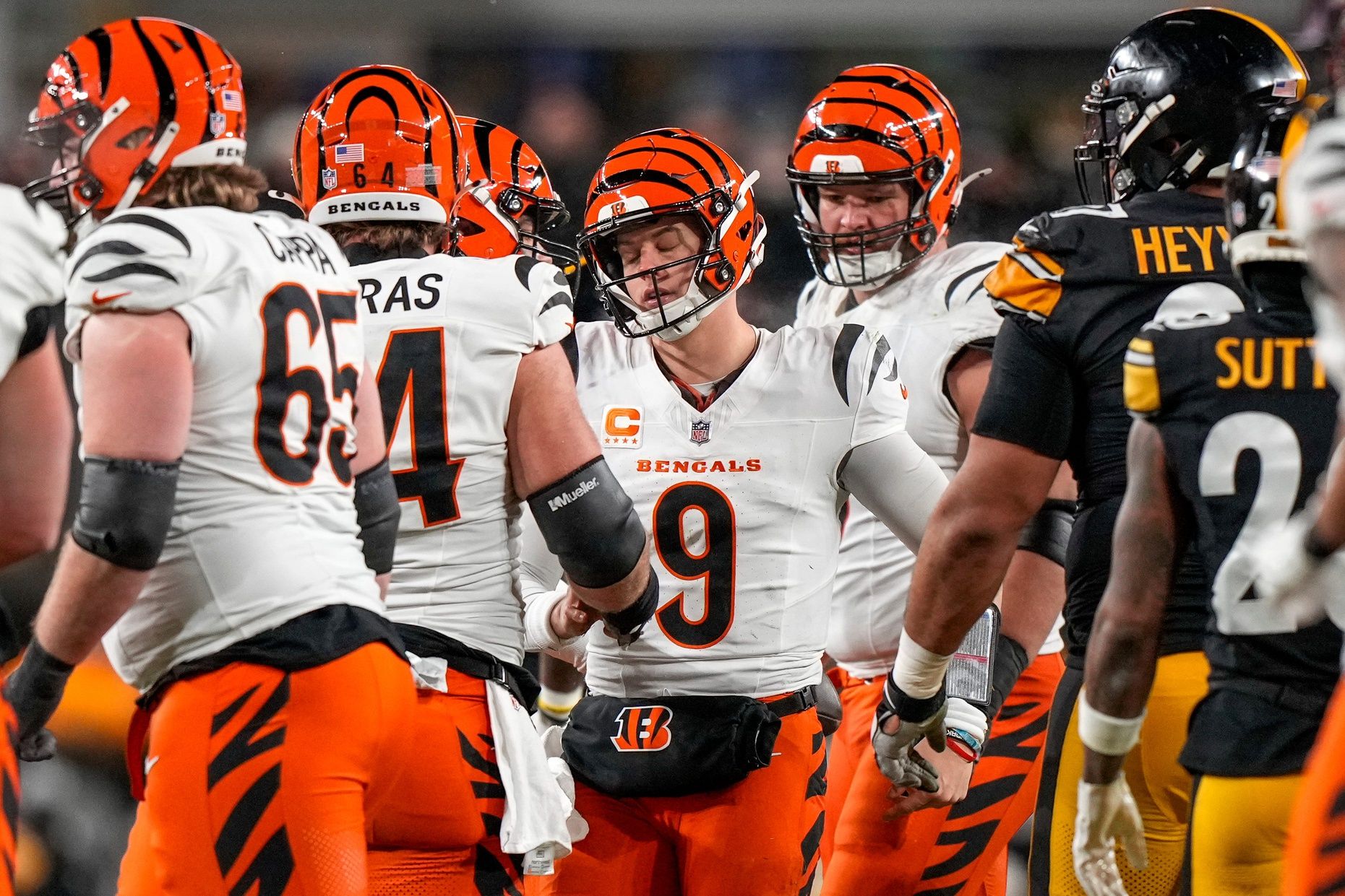 Cincinnati Bengals quarterback Joe Burrow (9) is pulled back to his feet after being sacked in the second quarter of the NFL Week 18 game between the Pittsburgh Steelers and the Cincinnati Bengals at Acrisure Stadium in Pittsburgh on Saturday, Jan. 4, 2025.