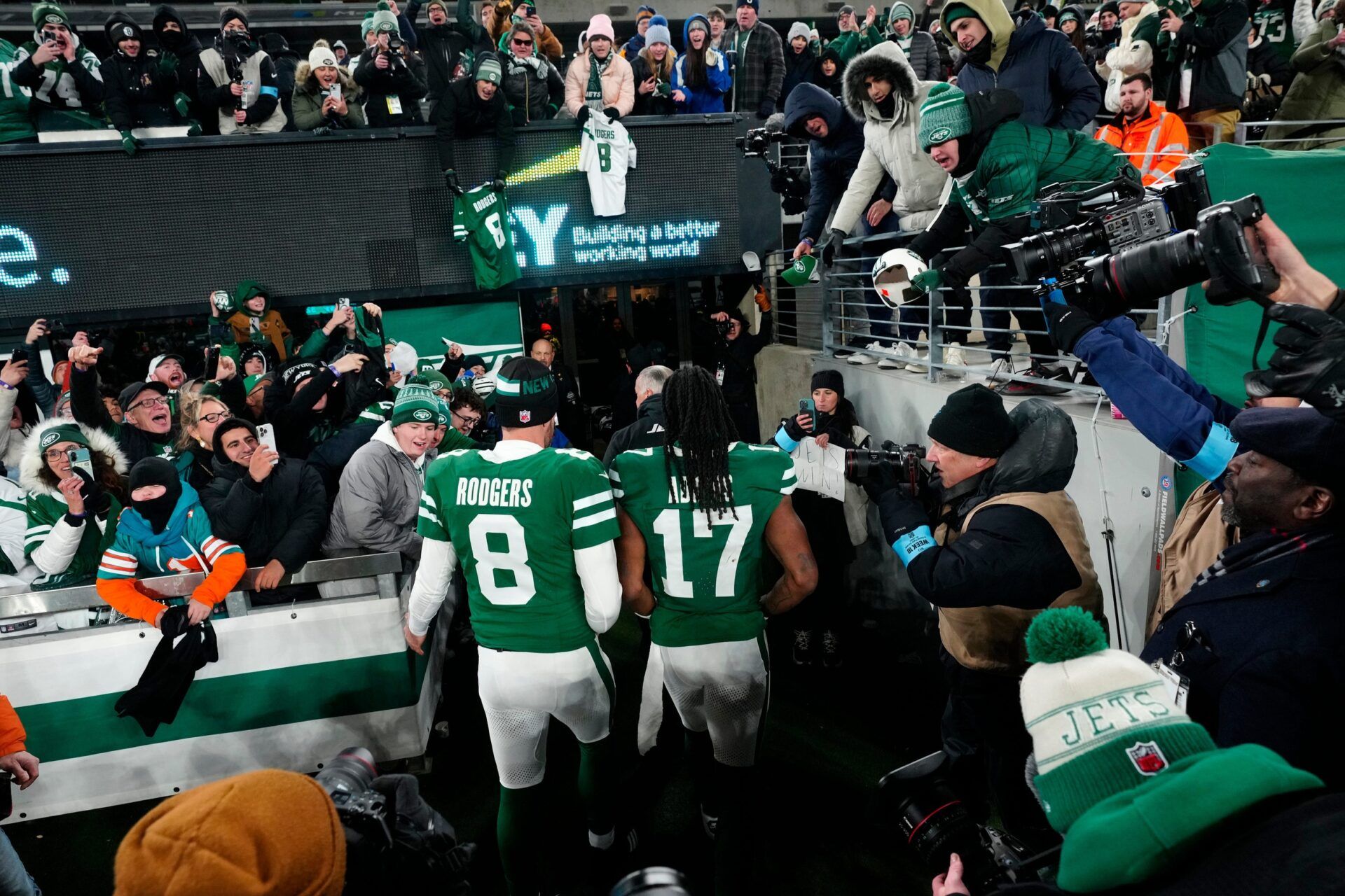 New York Jets quarterback Aaron Rodgers (8) and New York Jets wide receiver Davante Adams (17) step off the field to cheering fans, Sunday January 5, 2025, in East Rutherford.