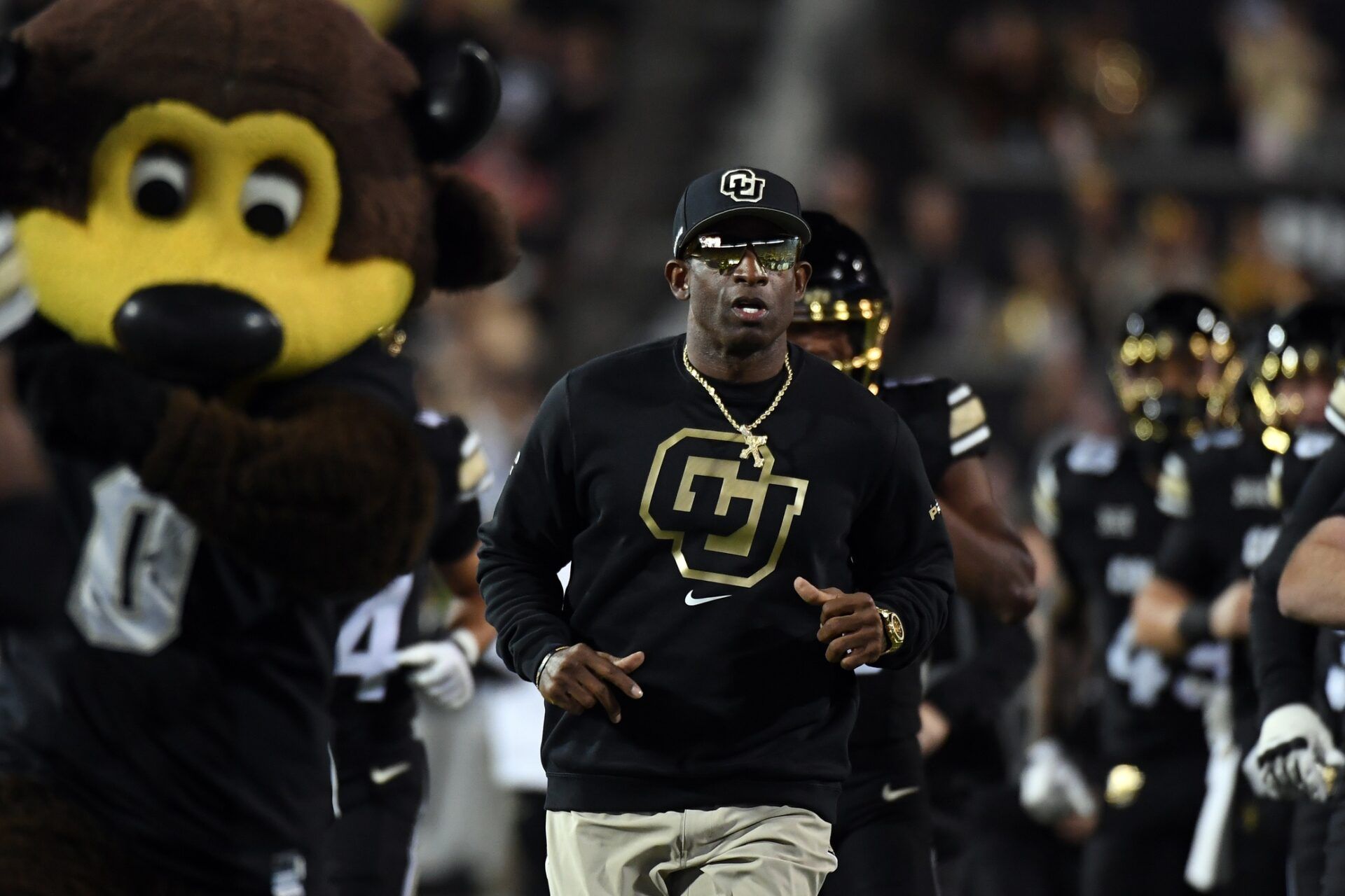 Colorado Buffaloes head coach Deion Sanders runs onto the field with his team before the game against the Kansas State Wildcats at Folsom Field