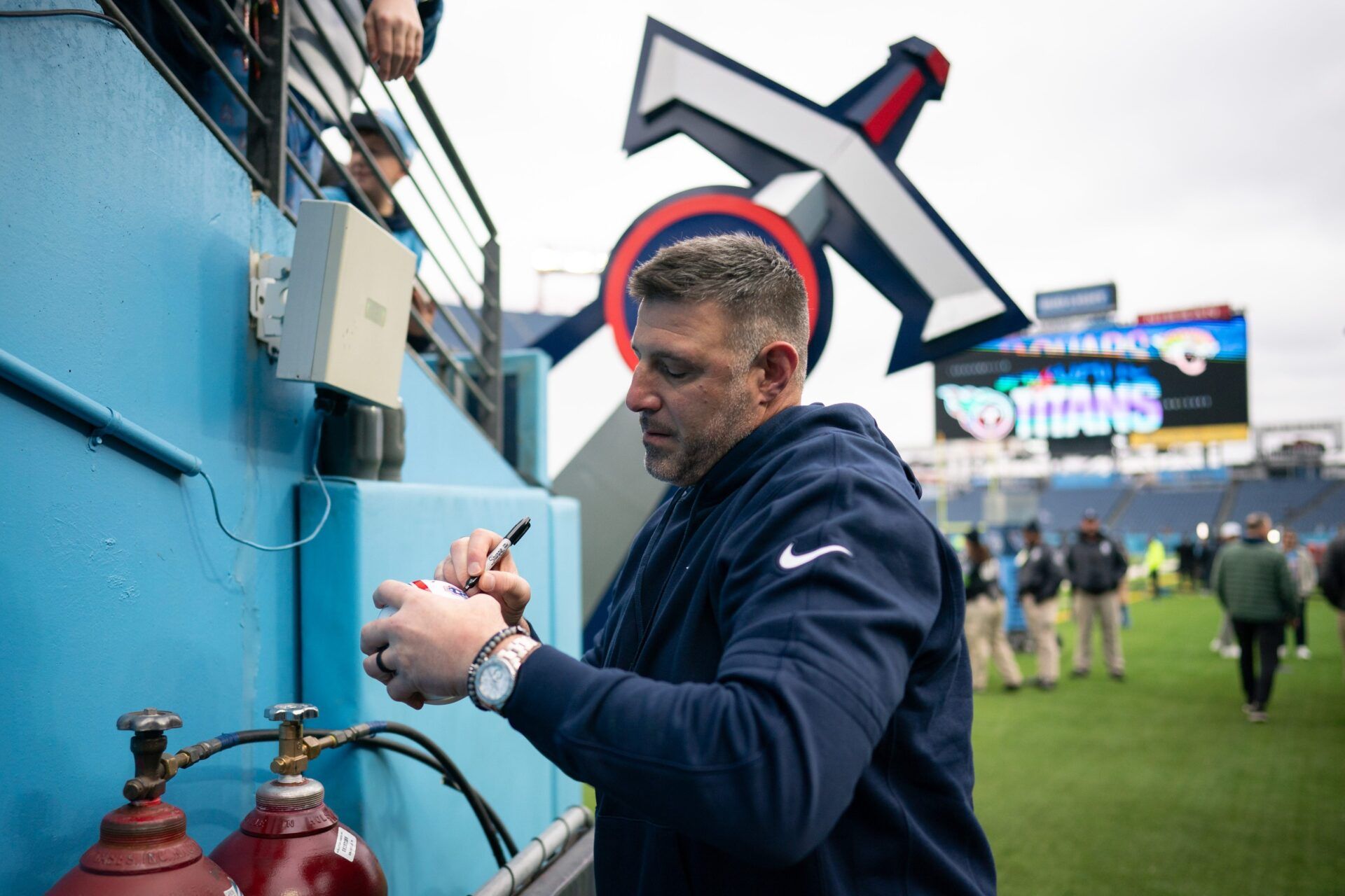 Tennessee Titans head coach Mike Vrabel sighs an autograph before a game against the Jacksonville Jaguars at Nissan Stadium in Nashville, Tenn., Sunday, Jan. 7, 2024.