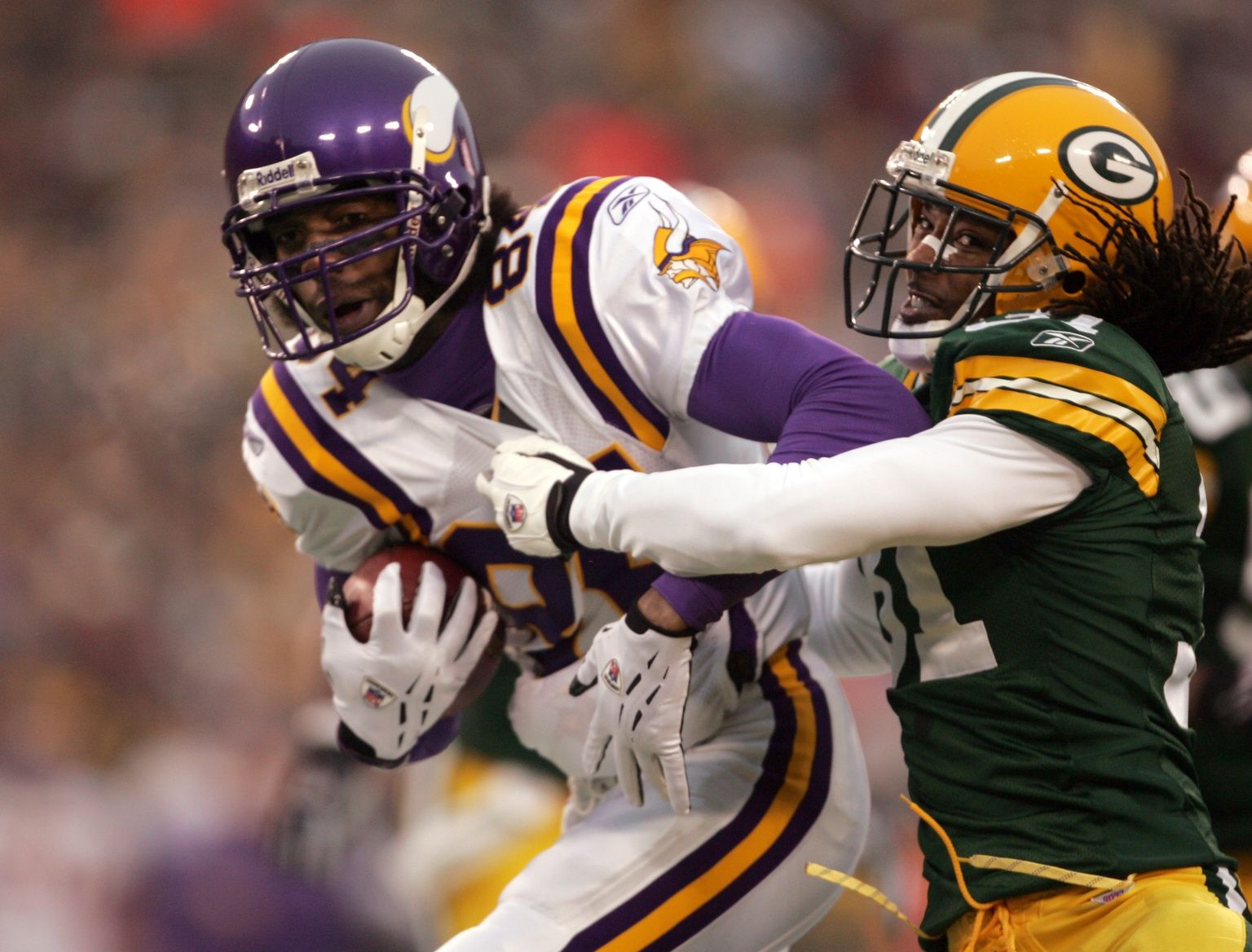 The Minnesota Vikings (84) Randy Moss catches a 7-yard Daunte Culpepper (not pictured) pass as Green Bay defensive back Al Harris defends in the first quarter of the 2004 NFC Wild Card Playoff Game at Lambeau Field.