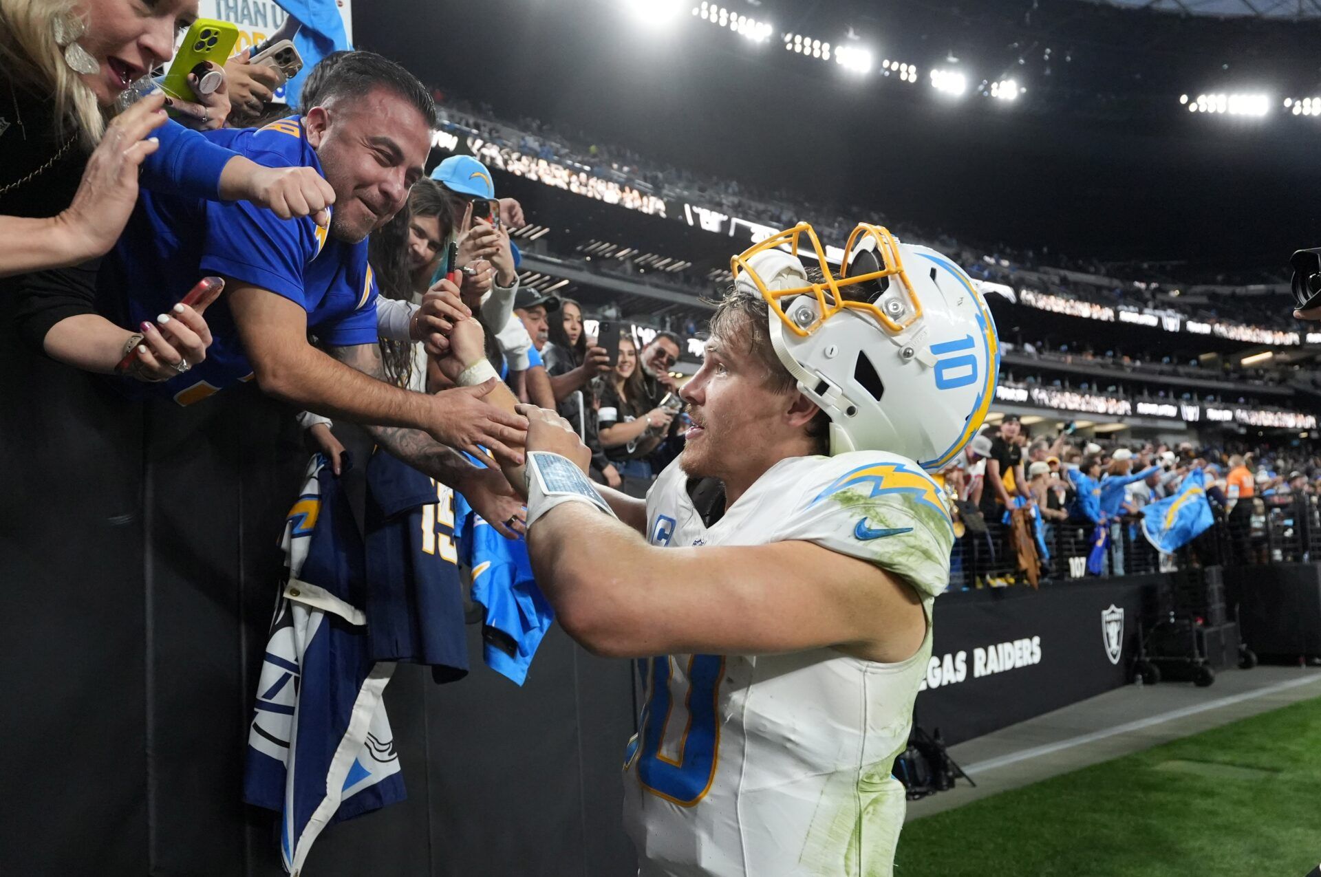 Los Angeles Chargers quarterback Justin Herbert (10) interacts with fans after the game against the Las Vegas Raiders at Allegiant Stadium.