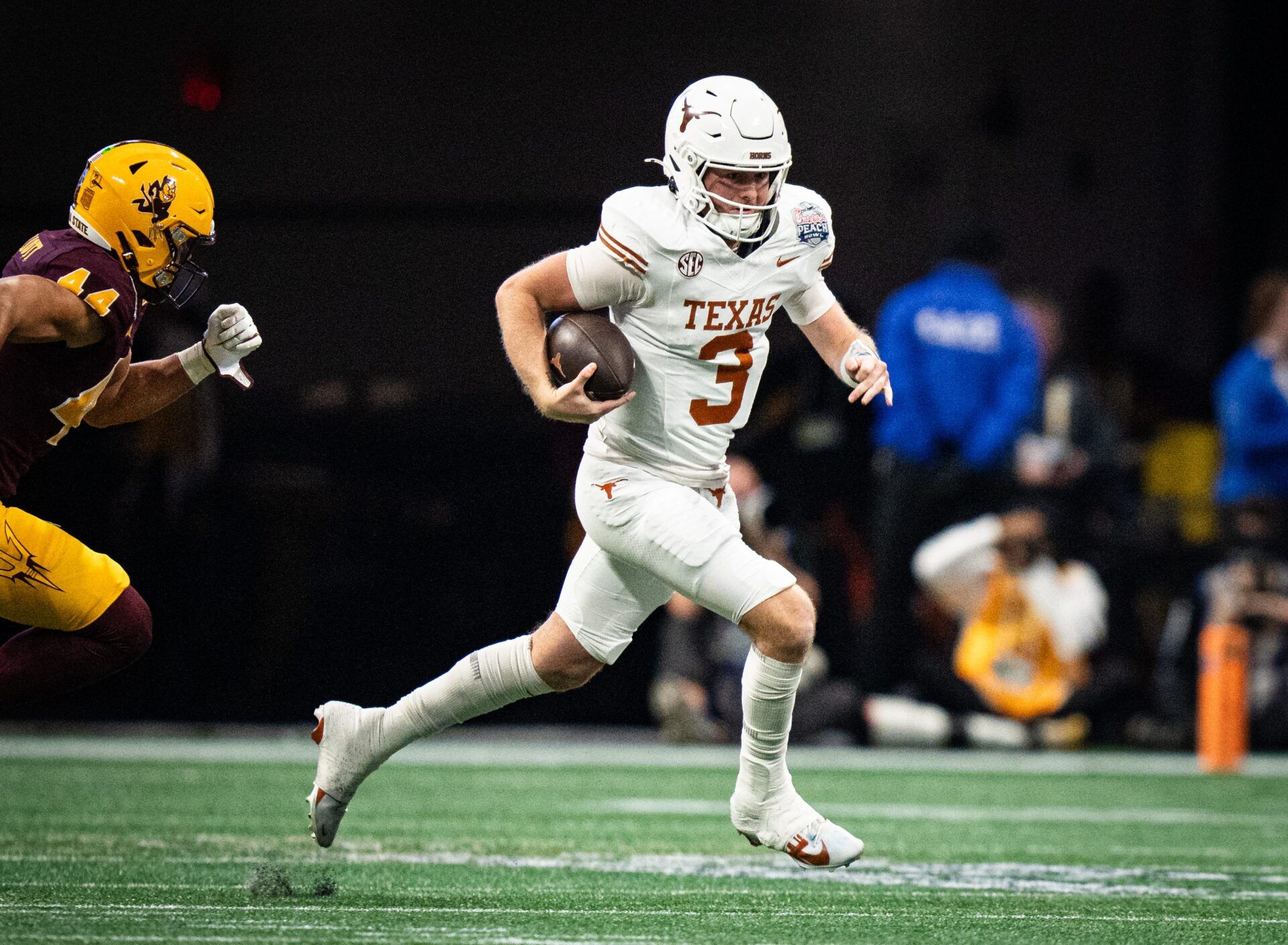 Texas Longhorns quarterback Quinn Ewers (3) runs the ball as Arizona State Sun Devils linebacker Keyshaun Elliott (44) chases in the second quarter as the Texas Longhorns play the Arizona State Sun Devils in the Peach Bowl College Football Playoff quarterfinal at Mercedes-Benz Stadium in Atlanta, Georgia, Jan. 1, 2025.