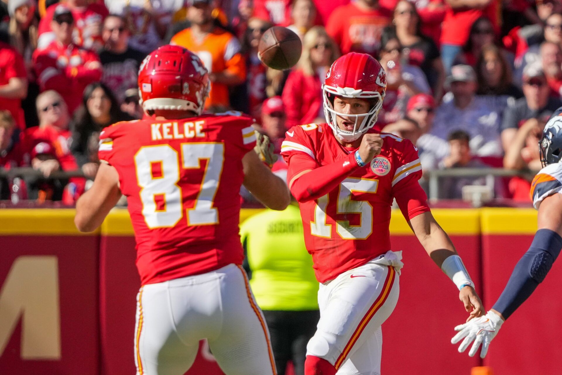 Nov 10, 2024; Kansas City, Missouri, USA; Kansas City Chiefs quarterback Patrick Mahomes (15) throws to tight end Travis Kelce (87) against the Denver Broncos during the first half at GEHA Field at Arrowhead Stadium. Mandatory Credit: Denny Medley-Imagn Images