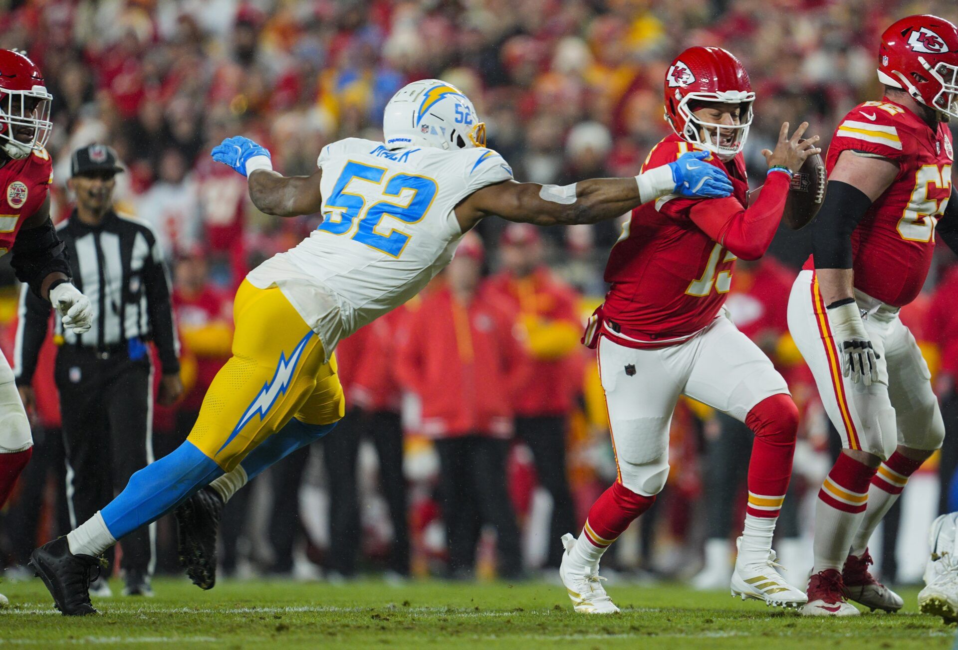 Kansas City Chiefs quarterback Patrick Mahomes (15) scrambles against Los Angeles Chargers linebacker Khalil Mack (52) during the first half at GEHA Field at Arrowhead Stadium.