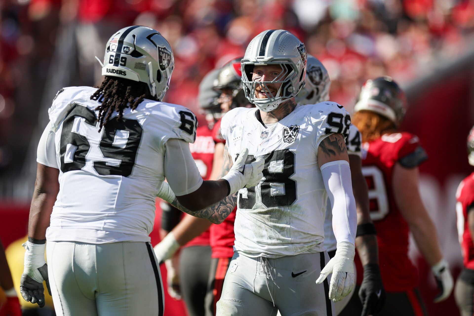 Las Vegas Raiders defensive end Maxx Crosby (98) and defensive tackle Adam Butler (69) reacts after a play against the Tampa Bay Buccaneers in the second quarter at Raymond James Stadium.