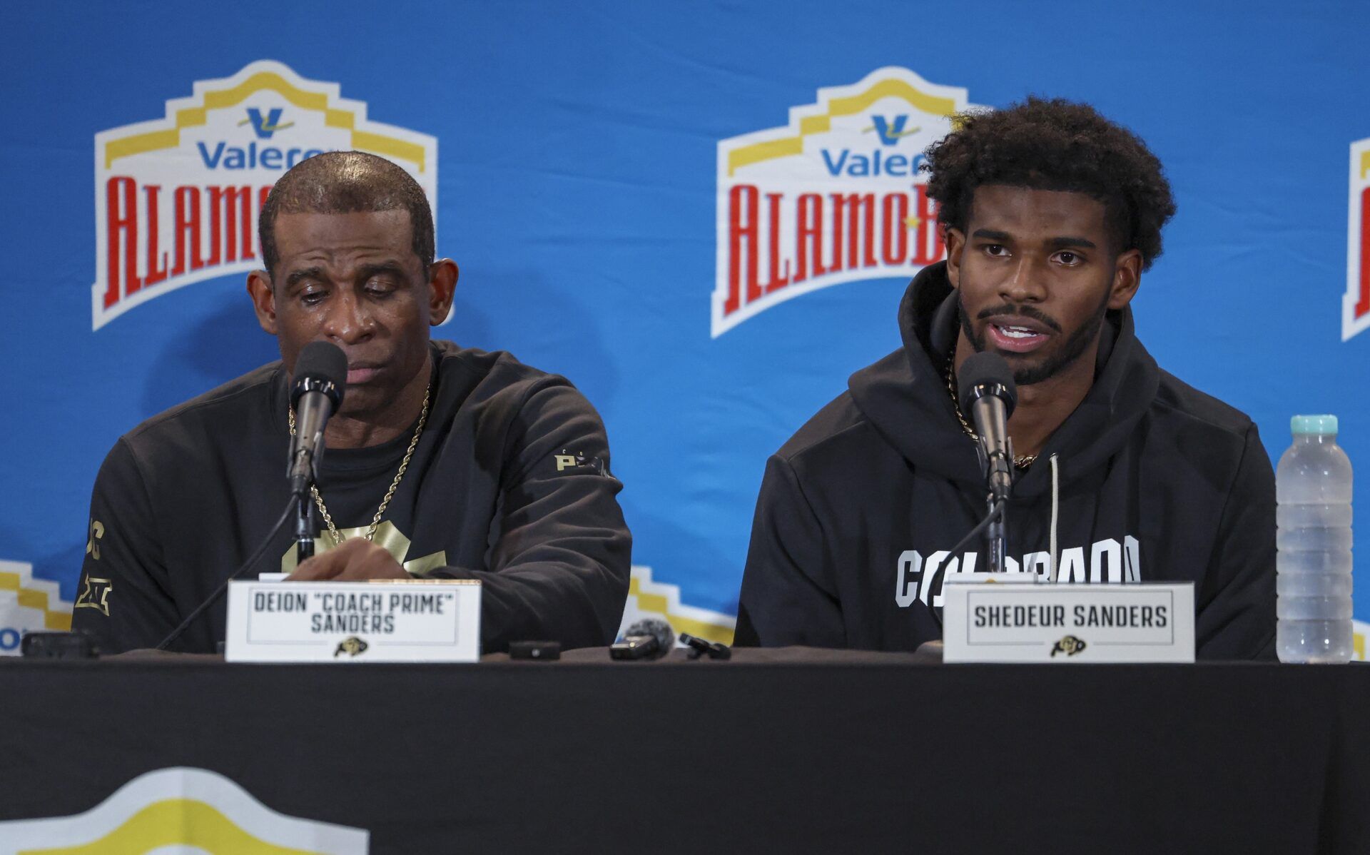 Colorado Buffaloes head coach Deion Sanders and quarterback Shedeur Sanders (2) talk with the media after the game against the Brigham Young Cougars at Alamodome.