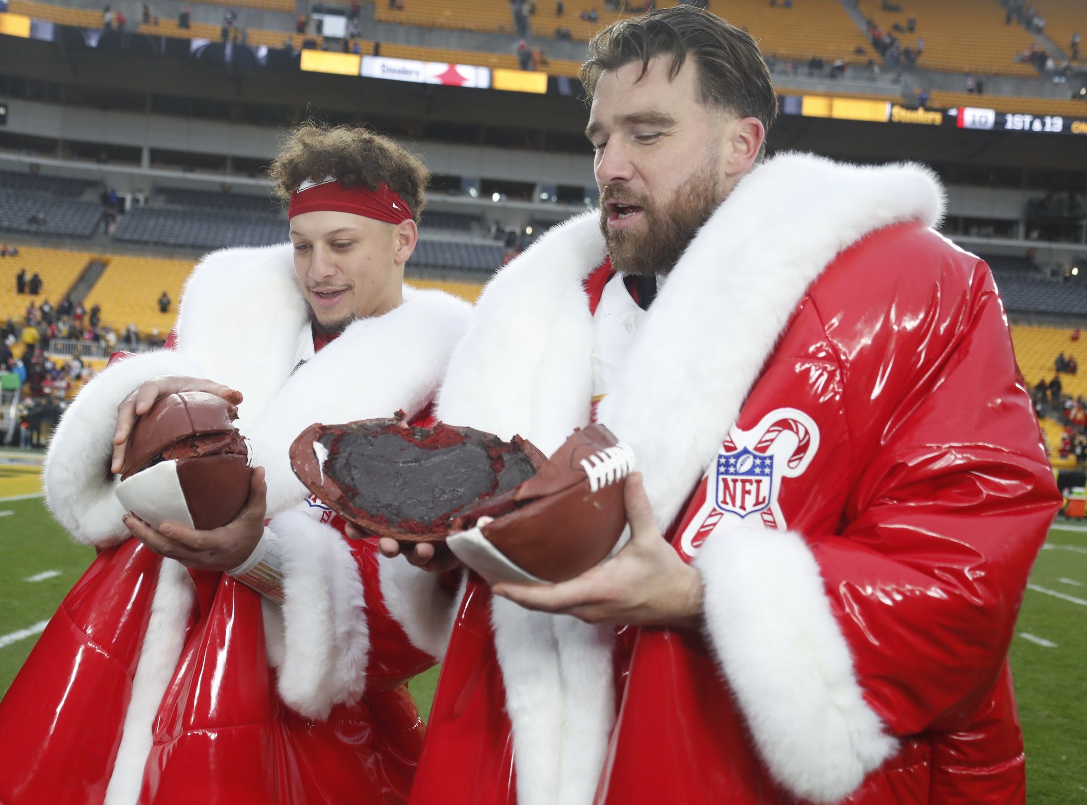 Kansas City Chiefs quarterback Patrick Mahomes (left) and tight end Travis Kelce (right) open their Netflix Christmas GameDay cake after the Chiefs defeated the Pittsburgh Steelers at Acrisure Stadium.