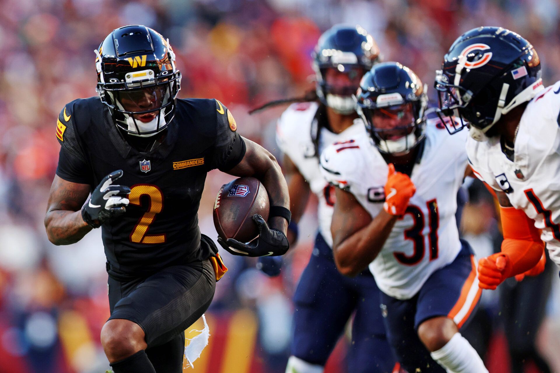 Oct 27, 2024; Landover, Maryland, USA; Washington Commanders wide receiver Dyami Brown (2) runs the ball against Chicago Bears cornerback Jaylon Johnson (1) during the first quarter at Commanders Field. Mandatory Credit: Peter Casey-Imagn Images