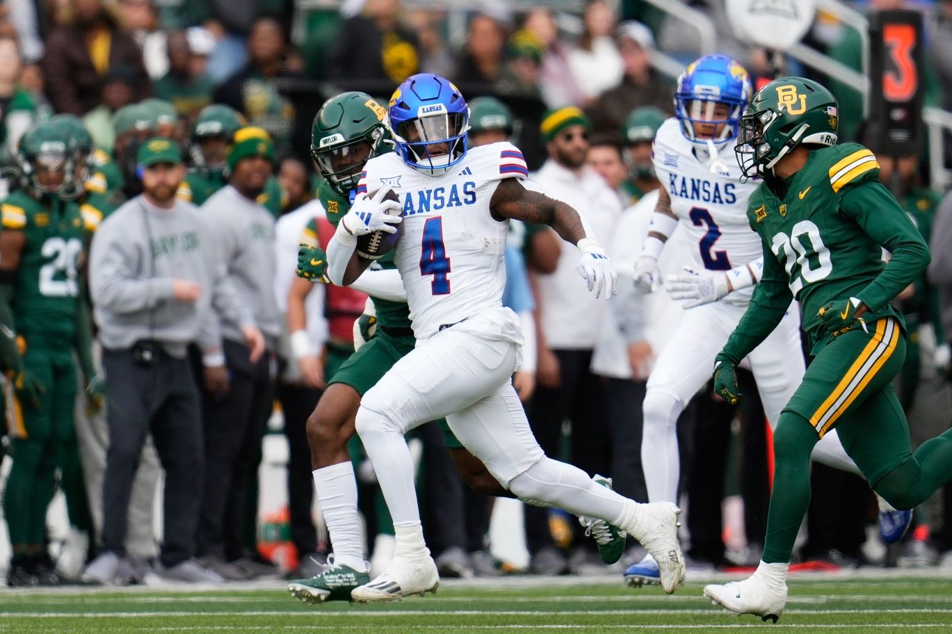 Kansas Jayhawks running back Devin Neal (4) runs with the ball as Baylor Bears safety Devin Lemear (20) gives chase during the first half at McLane Stadium.