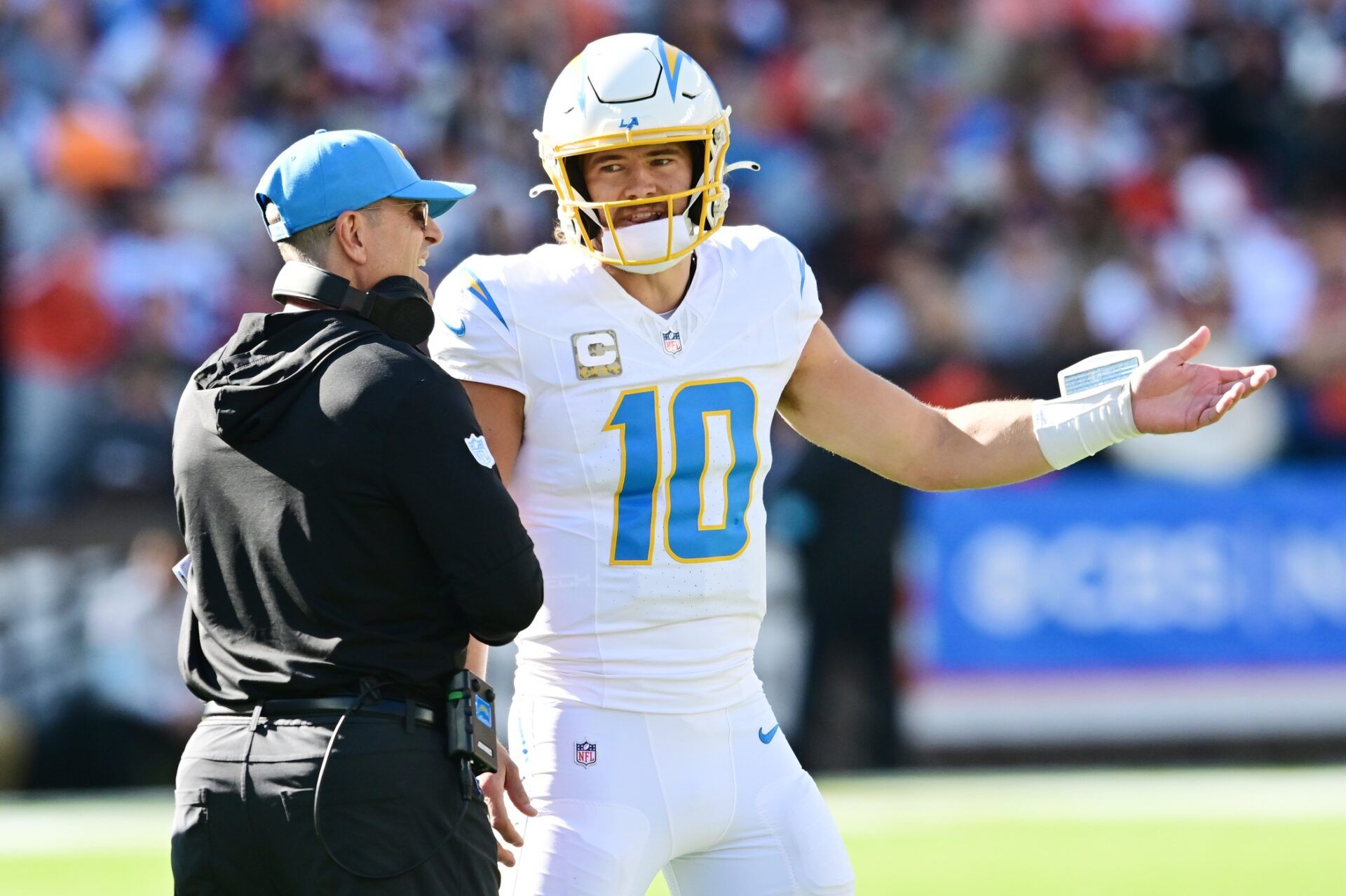 Los Angeles Chargers quarterback Justin Herbert (10) talks to head coach Jim Harbaugh during the first quarter against the Cleveland Browns at Huntington Bank Field.