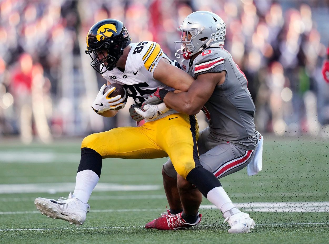 Ohio State Buckeyes linebacker Cody Simon (0) tackles Iowa Hawkeyes tight end Luke Lachey (85) after a catch in the third quarter during the NCAA football game at Ohio Stadium.