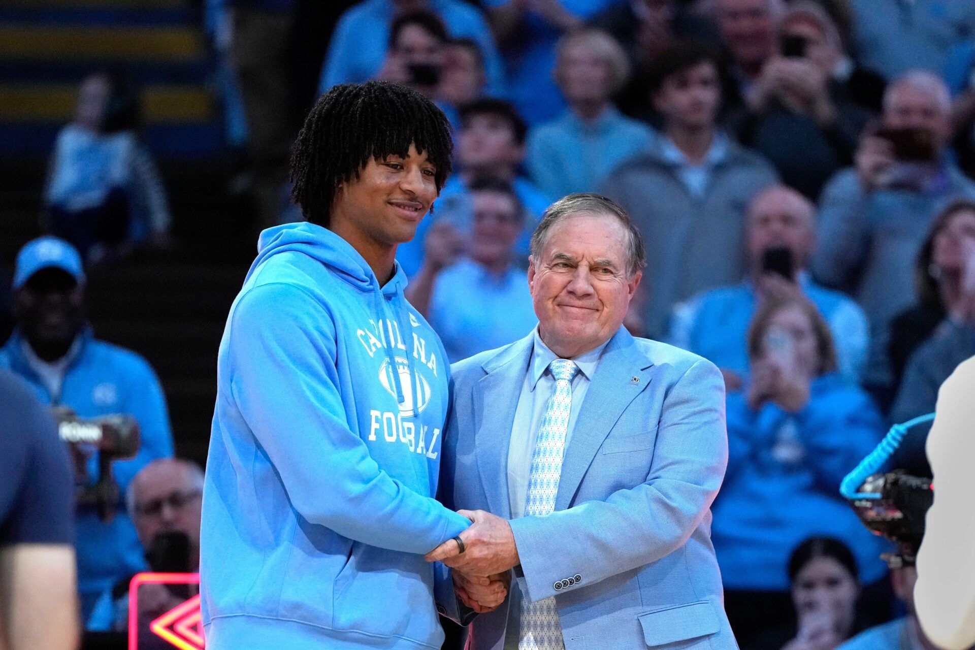 North Carolina Tar Heels head football coach Bill Belichick with recruit quarterback Bryce Baker during half time at Dean E. Smith Center.