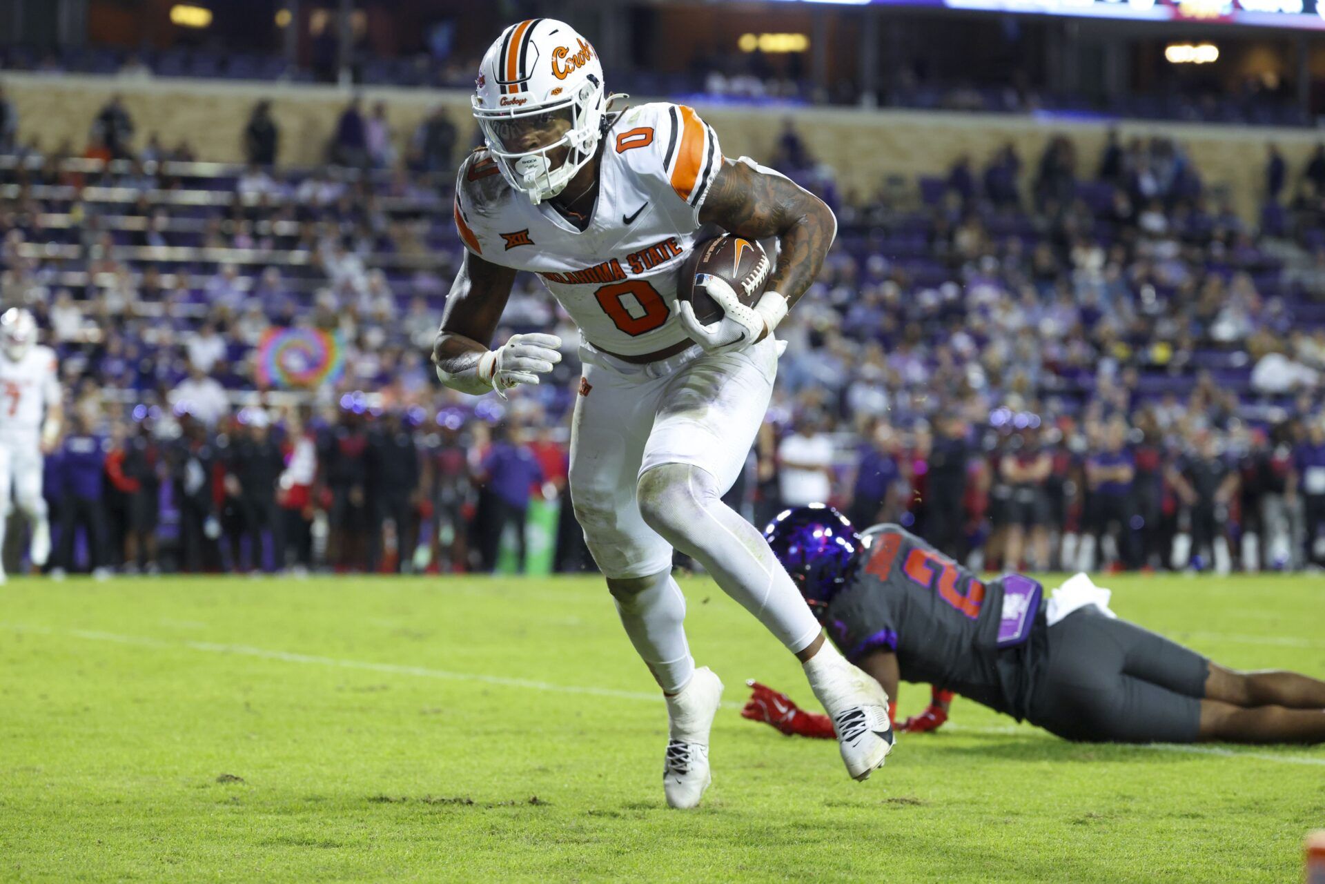 Oklahoma State Cowboys running back Ollie Gordon II (0) scores a touchdown past TCU Horned Frogs safety Jamel Johnson (2) during the second half at Amon G. Carter Stadium.