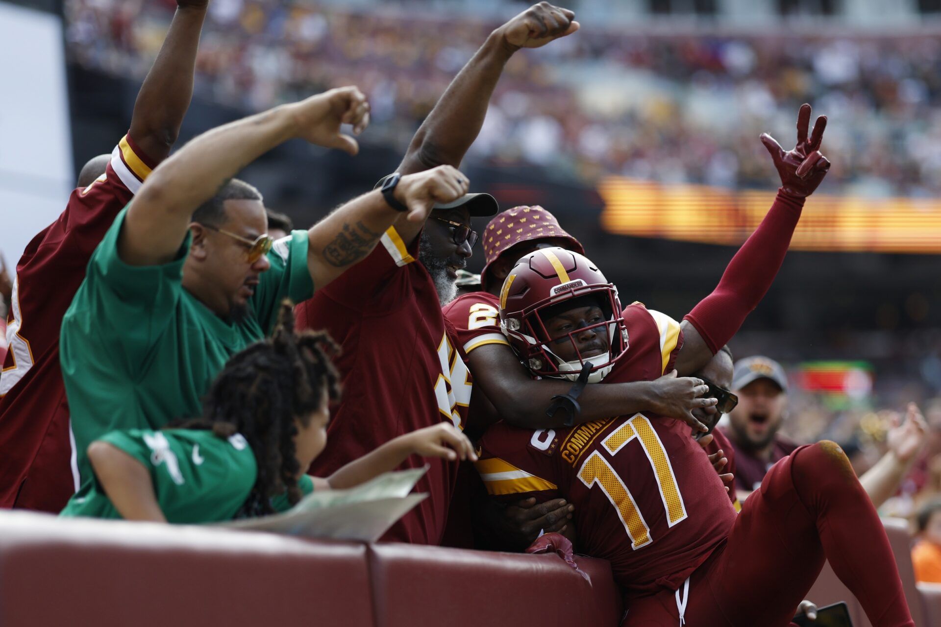 Washington Commanders wide receiver Terry McLaurin (17) leaps into the stands to celebrate with fans after catching a touchdown pass against the Philadelphia Eagles during the first quarter at FedExField.