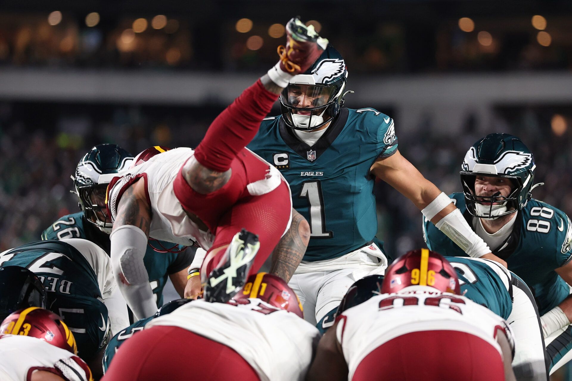 Jan 26, 2025; Philadelphia, PA, USA; Philadelphia Eagles quarterback Jalen Hurts (1) reacts as Washington Commanders linebacker Frankie Luvu (4) leaps over linemen before a snap during the second half in the NFC Championship game at Lincoln Financial Field. Mandatory Credit: Bill Streicher-Imagn Images