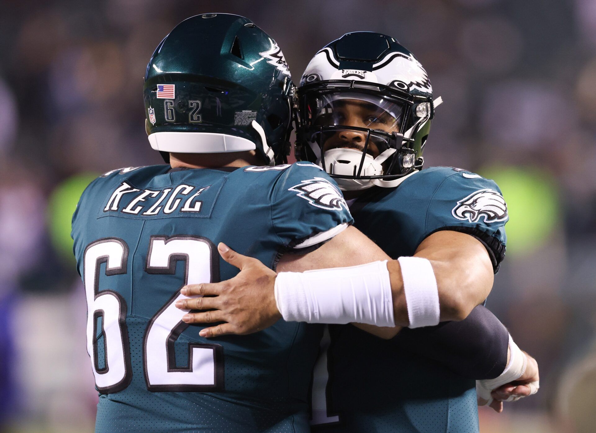 Philadelphia Eagles center Jason Kelce (62) and quarterback Jalen Hurts (1) embrace before a game against the New York Giants during an NFC divisional round game at Lincoln Financial Field.