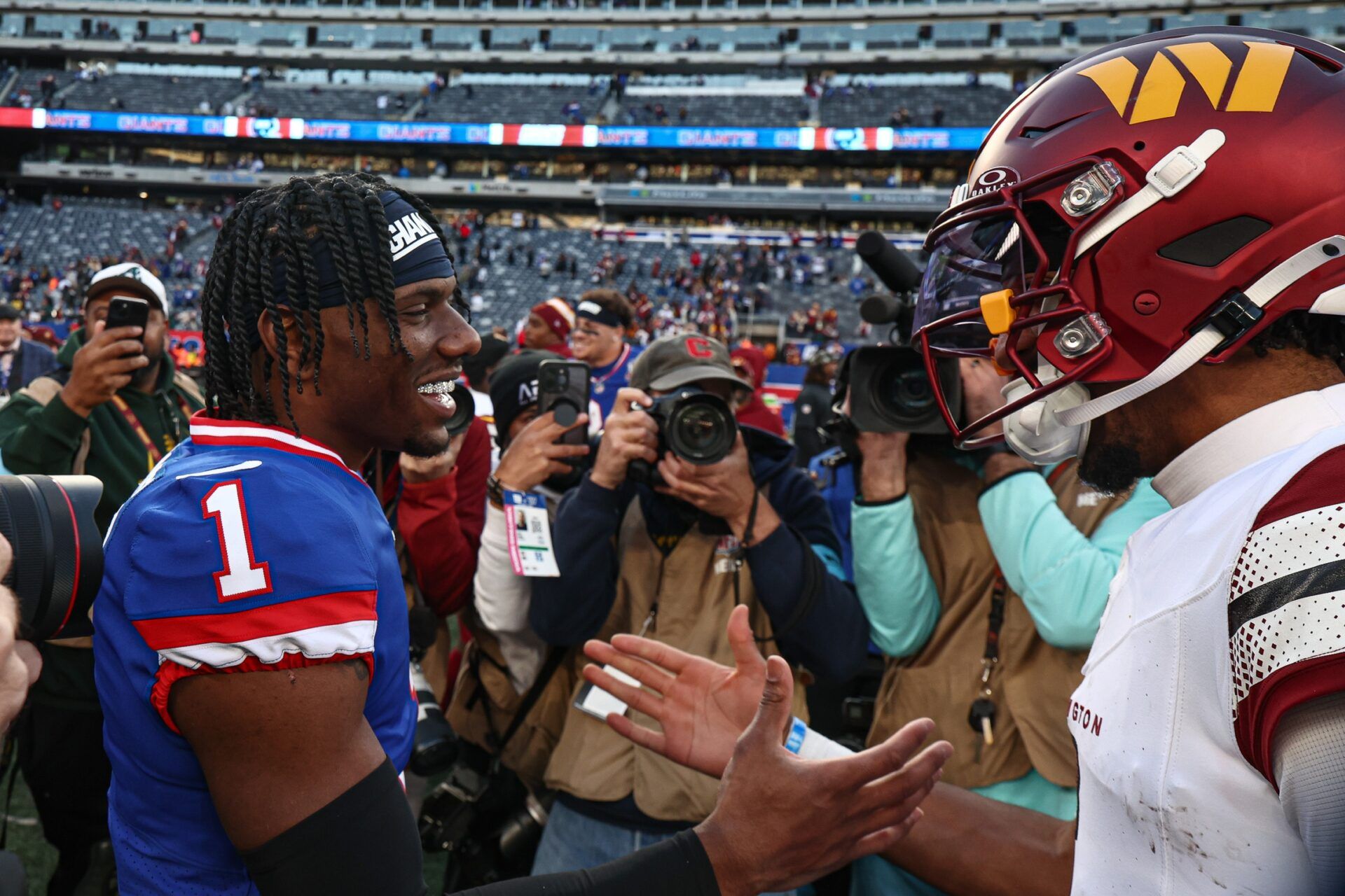 New York Giants wide receiver Malik Nabers (1) shakes hands with Washington Commanders quarterback Jayden Daniels (5) after the game at MetLife Stadium.