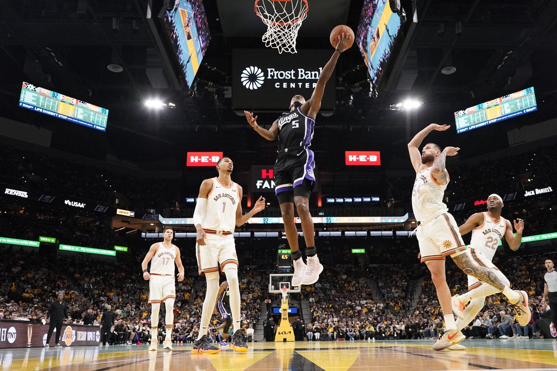 Sacramento Kings guard De'Aaron Fox (5) drives to the basket between San Antonio Spurs forwards Victor Wembanyama (1) and Sandro Mamukelashvili (54) during the second half at Frost Bank Center.