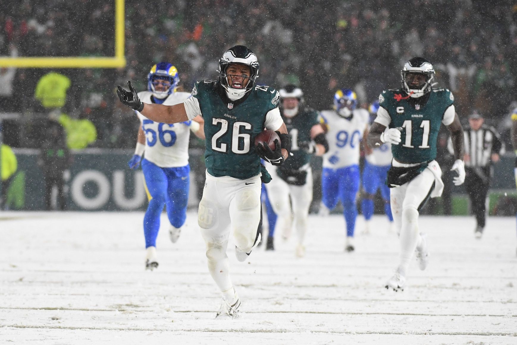 Philadelphia Eagles running back Saquon Barkley (26) carries the ball to score a touchdown against the Los Angeles Rams in the second half in a 2025 NFC divisional round game at Lincoln Financial Field.