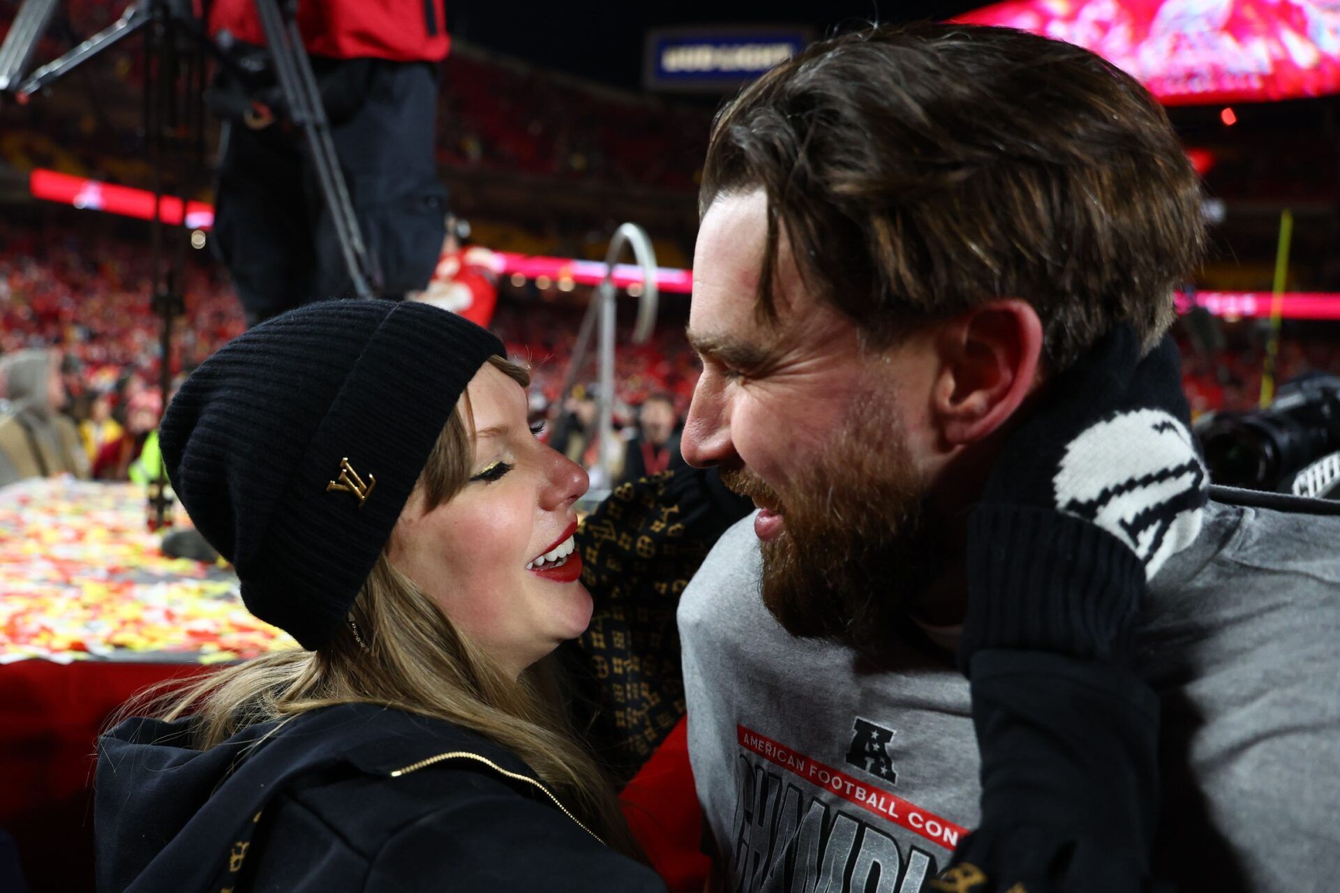 Recording artist Taylor Swift and Kansas City Chiefs tight end Travis Kelce (87) react after the AFC Championship game against the Buffalo Bills at GEHA Field at Arrowhead Stadium