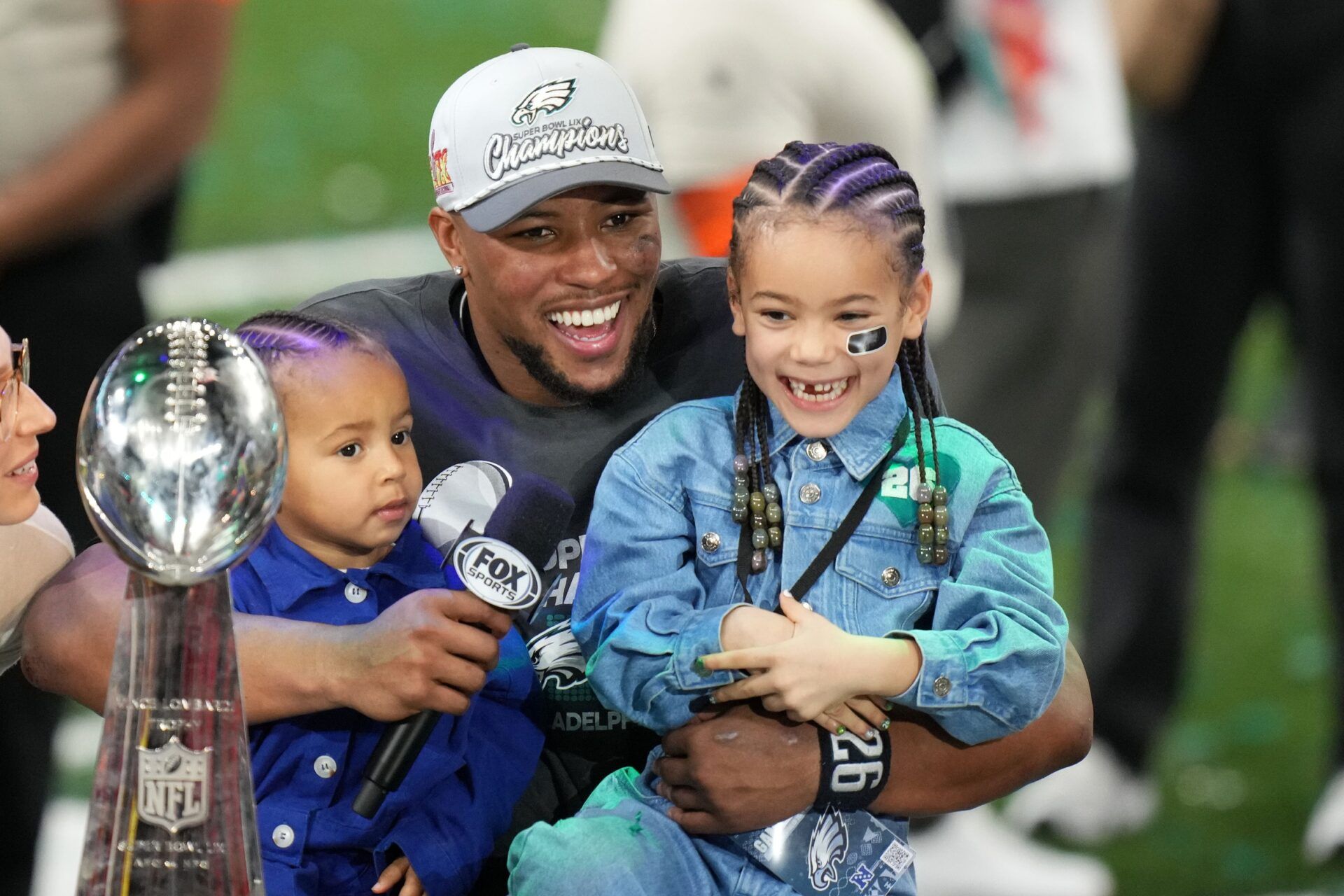 Philadelphia Eagles running back Saquon Barkley (26) talks to the media with his kids, Jada (right) and Saquon Jr. (left) after defeating the Kansas City Chiefs in Super Bowl 59 at Caesars Superdome.