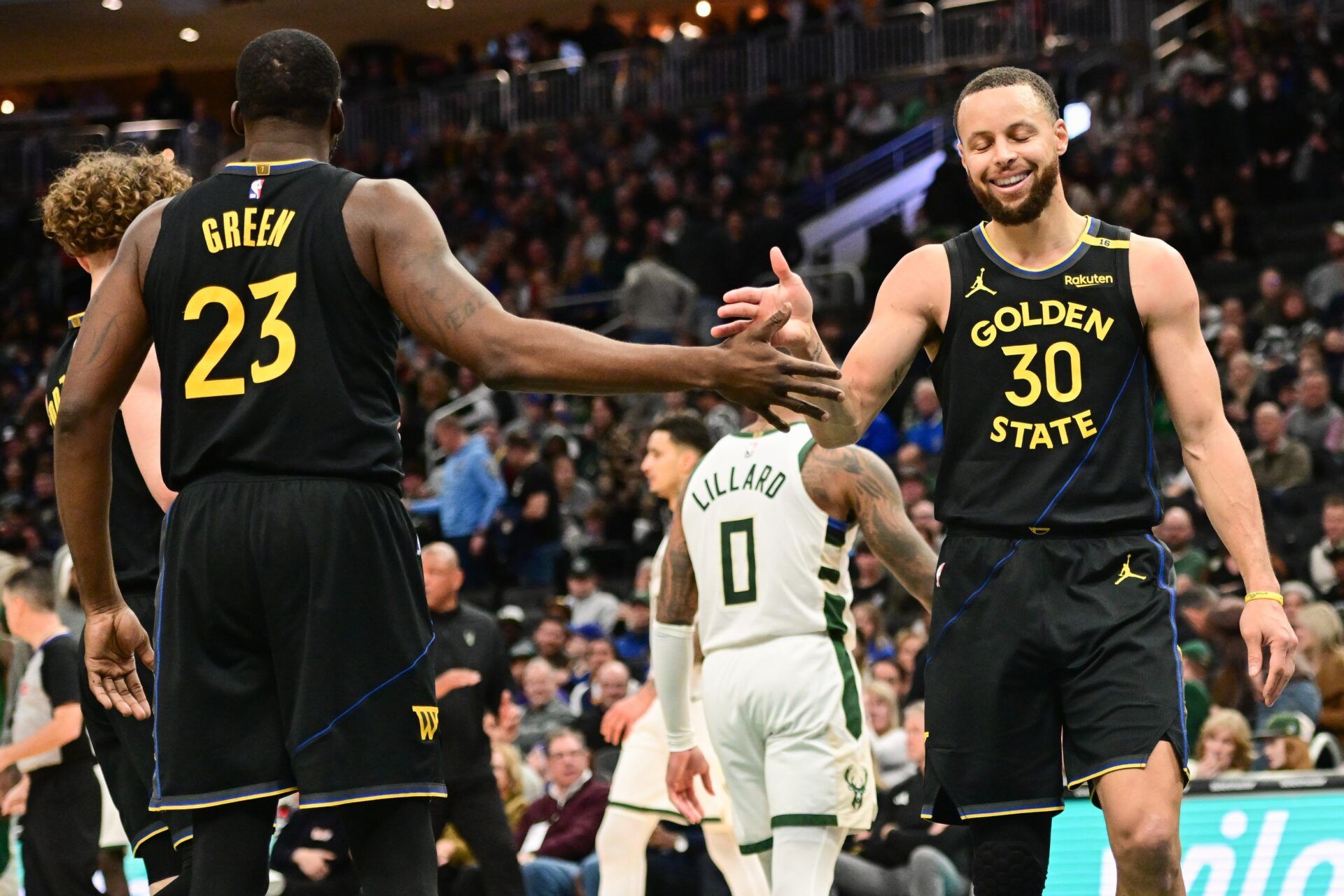 Golden State Warriors guard Stephen Curry (30) celebrates with forward Draymond Green (23) in the fourth quarter against the Milwaukee Bucks at Fiserv Forum.