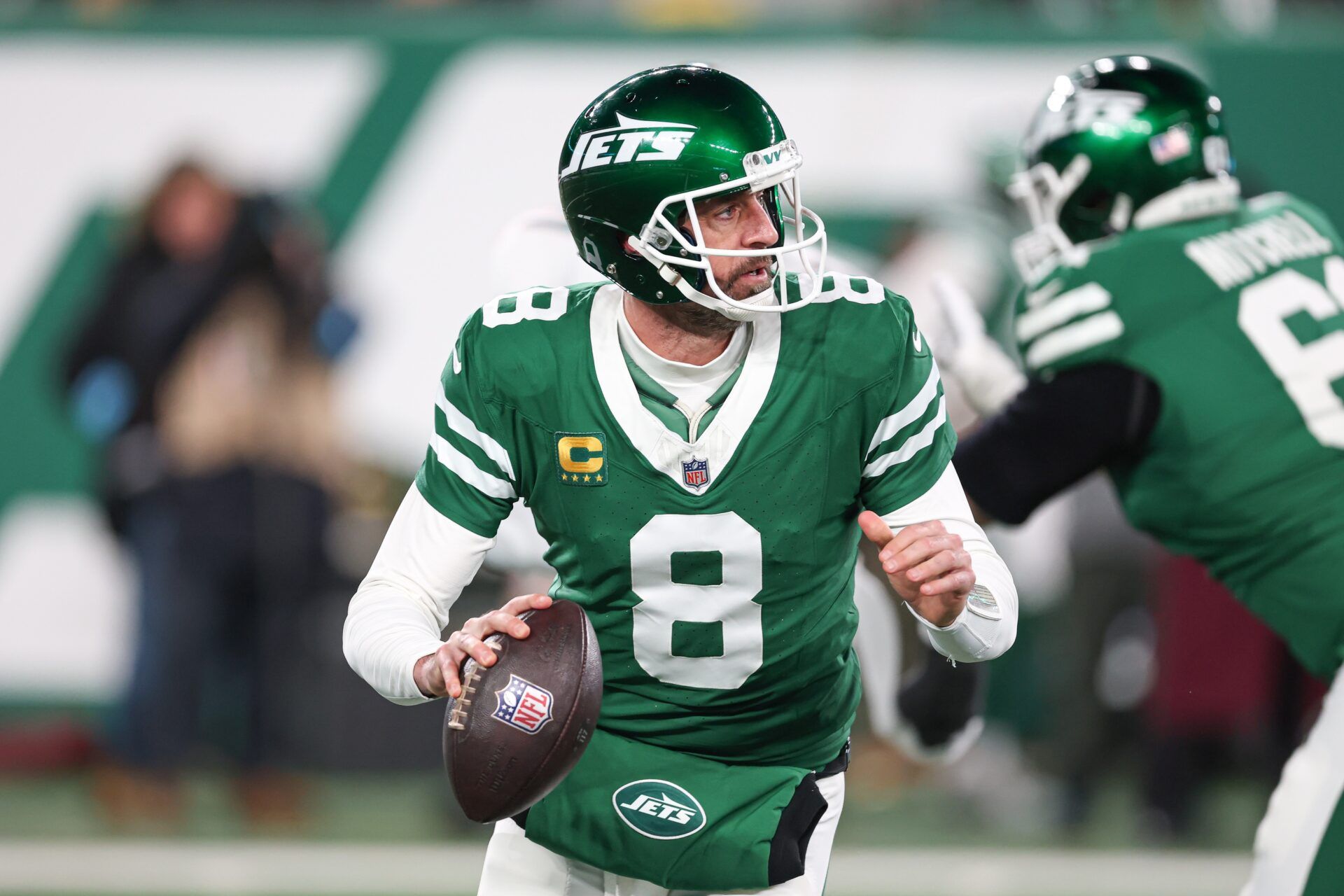 New York Jets quarterback Aaron Rodgers (8) rolls out during the first half against the Miami Dolphins at MetLife Stadium.