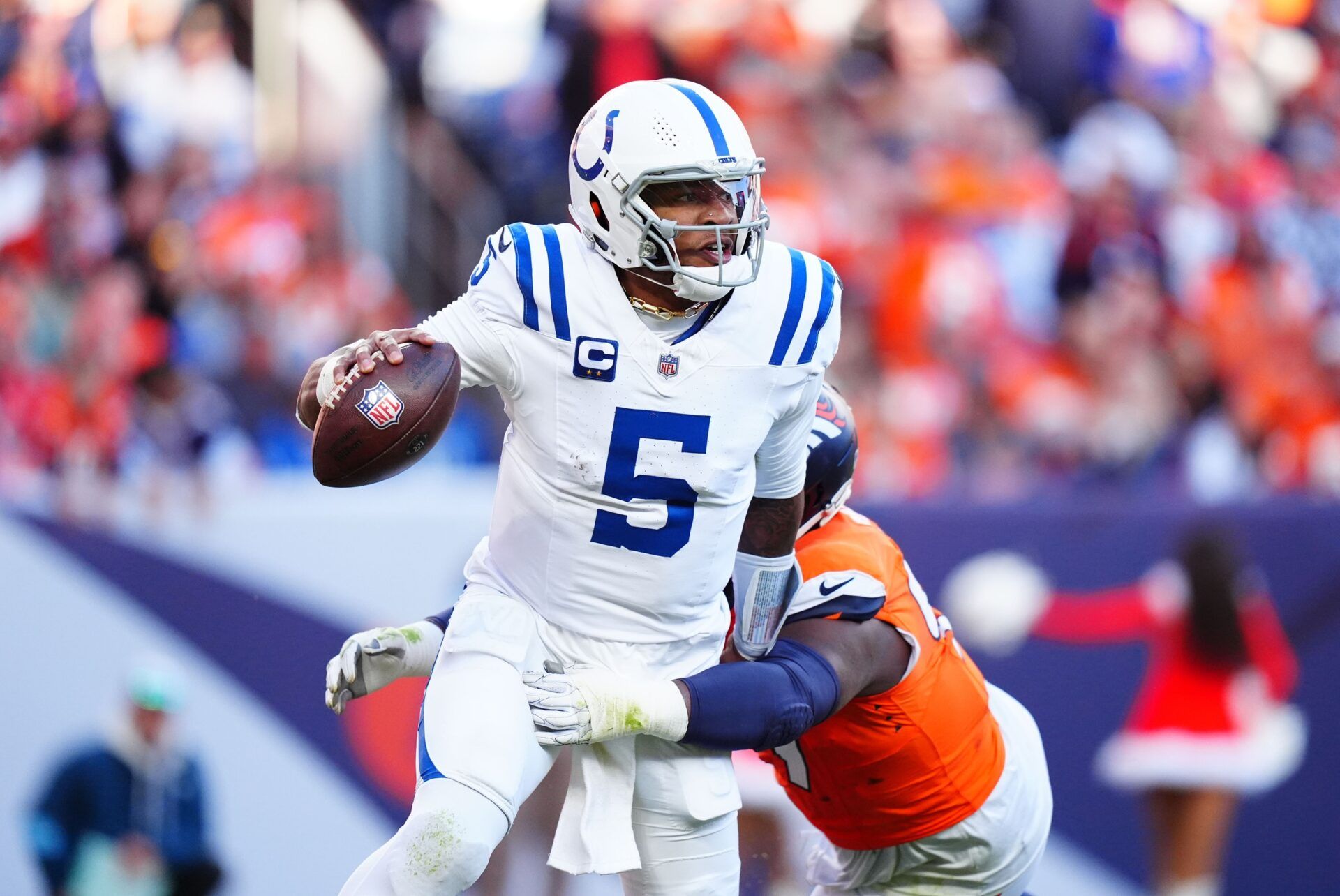 Indianapolis Colts quarterback Anthony Richardson (5) runs past the tackle of Denver Broncos defensive tackle Malcolm Roach (97) in the second quarter at Empower Field at Mile High.