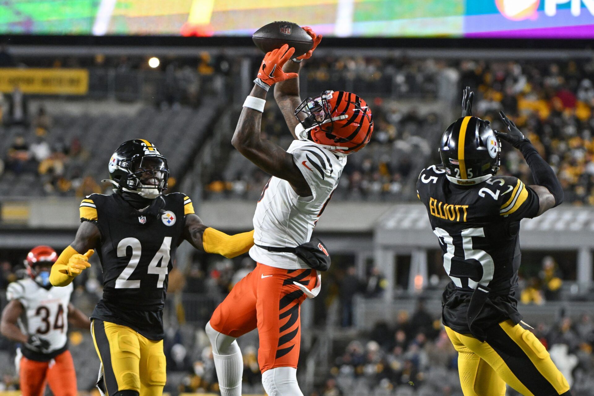 Cincinnati Bengals wide receiver Tee Higgins (5) catches a pass in front of Pittsburgh Steelers cornerback Joey Porter Jr. (24) and safety DeShon Elliott (25) during the second quarter at Acrisure Stadium.