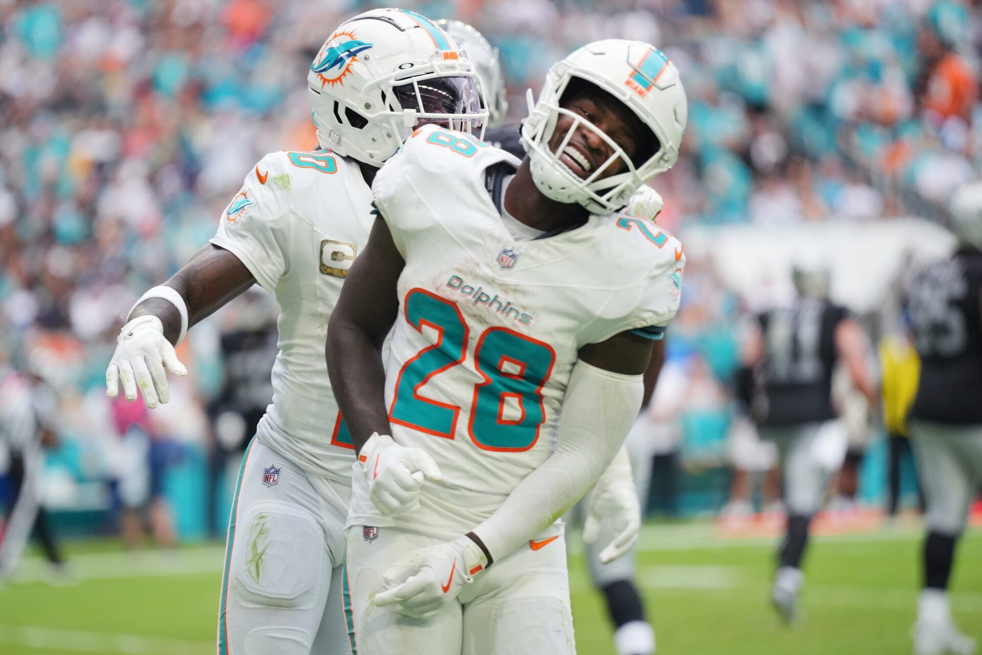 Miami Dolphins running back De'Von Achane (28) celebrates a touchdown against the Las Vegas Raiders with wide receiver Tyreek Hill (10) at Hard Rock Stadium.