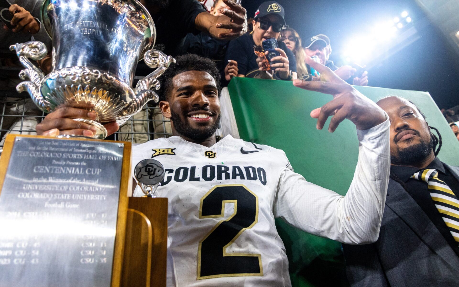 CU football quarterback Shedeur Sanders (2) poses with the Centennial Cup after beating CSU in the Rocky Mountain Showdown at Canvas Stadium