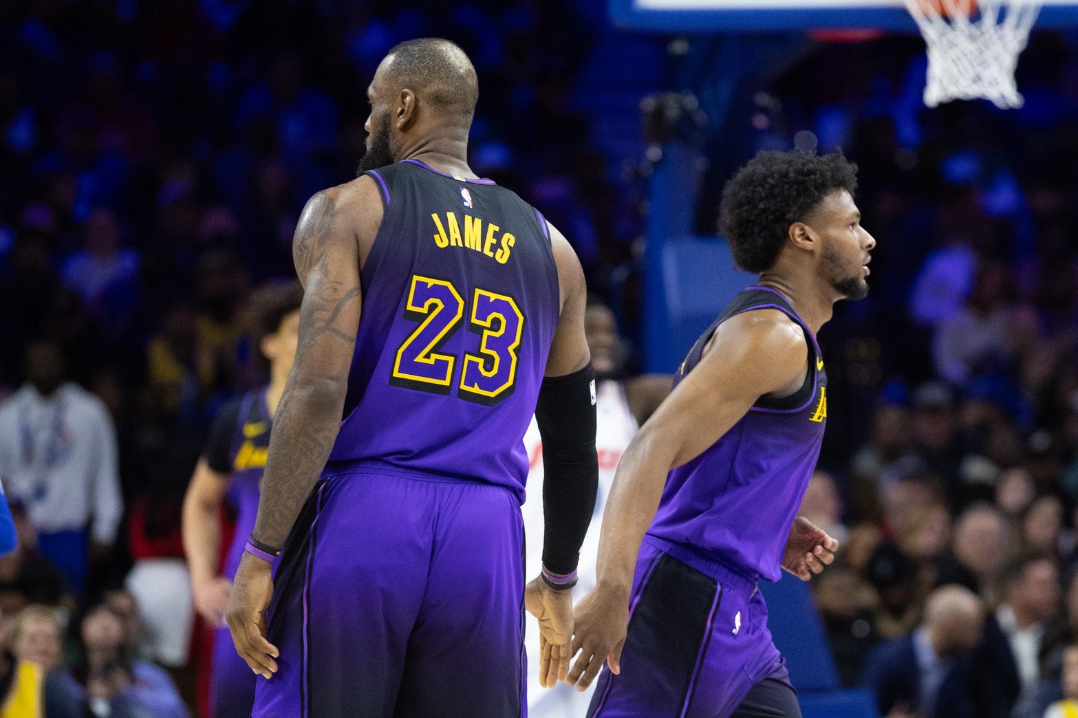 Los Angeles Lakers forward LeBron James (23) and guard Bronny James (9) slap hands before a substitution during the fourth quarter against the Philadelphia 76ers at Wells Fargo Center.