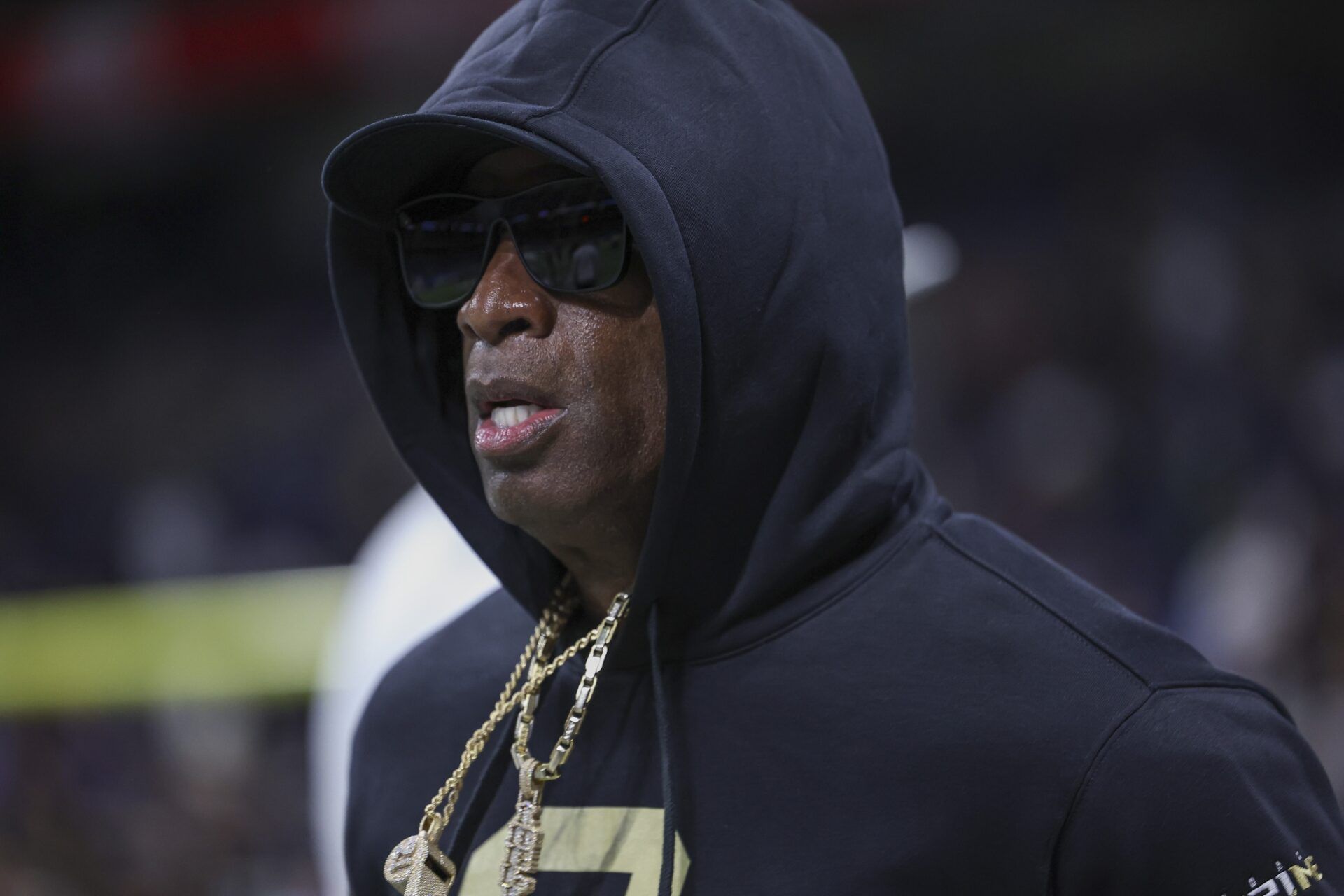 Colorado Buffaloes head coach Deion Sanders jogs on the field before the game against the Brigham Young Cougars at Alamodome.