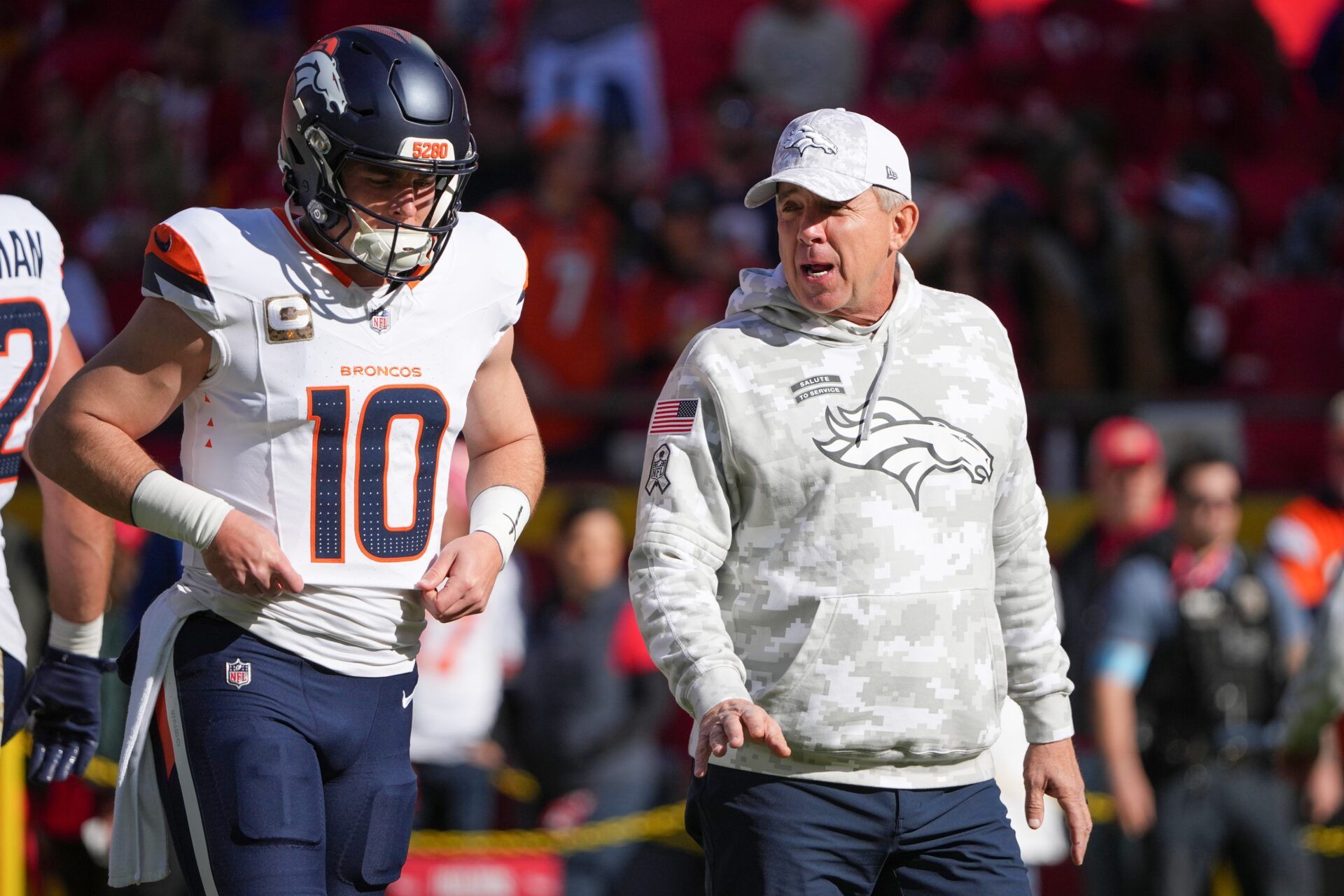 Denver Broncos quarterback Bo Nix (10) talks with head coach Sean Peyton against the Kansas City Chiefs prior to a game at GEHA Field at Arrowhead Stadium.