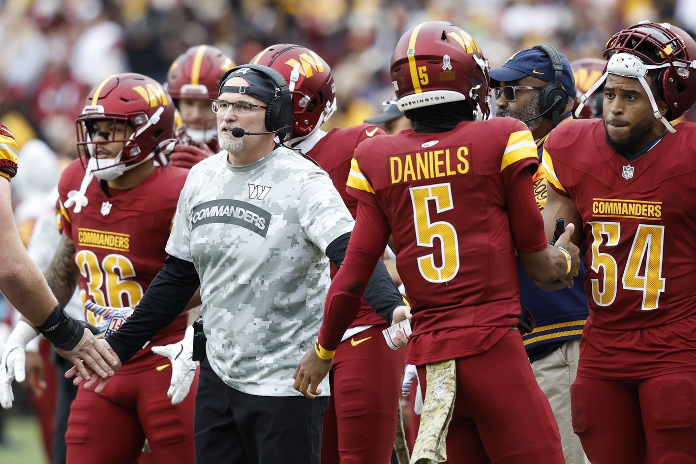 Washington Commanders head coach Dan Quinn (L) congratulates Commanders quarterback Jayden Daniels (5) after a touchdown drive against the Pittsburgh Steelers during the first half at Northwest Stadium.