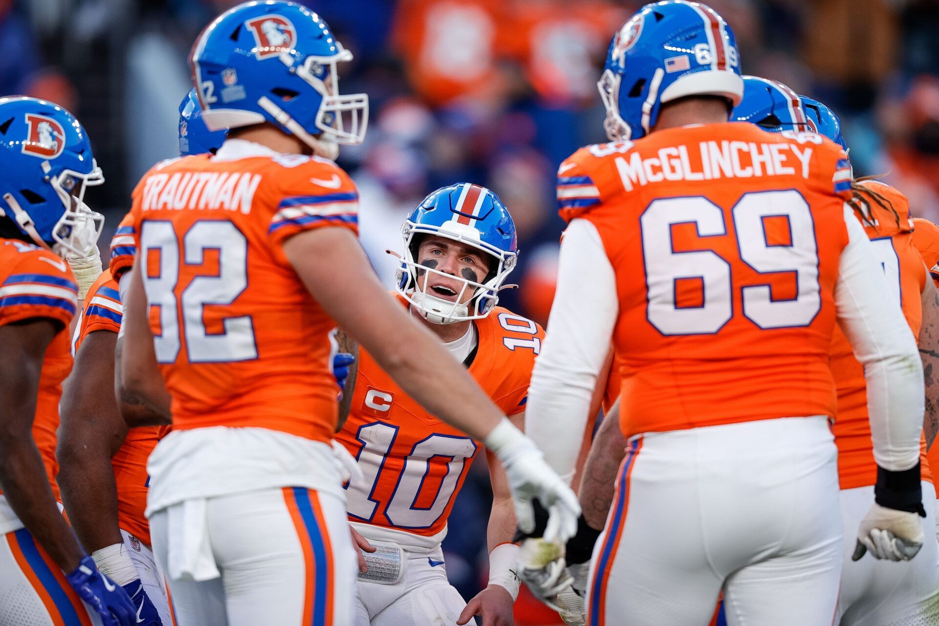 Denver Broncos quarterback Bo Nix (10) huddles with tight end Adam Trautman (82) and offensive tackle Mike McGlinchey (69) and teammates in the third quarter against the Kansas City Chiefs at Empower Field at Mile High.