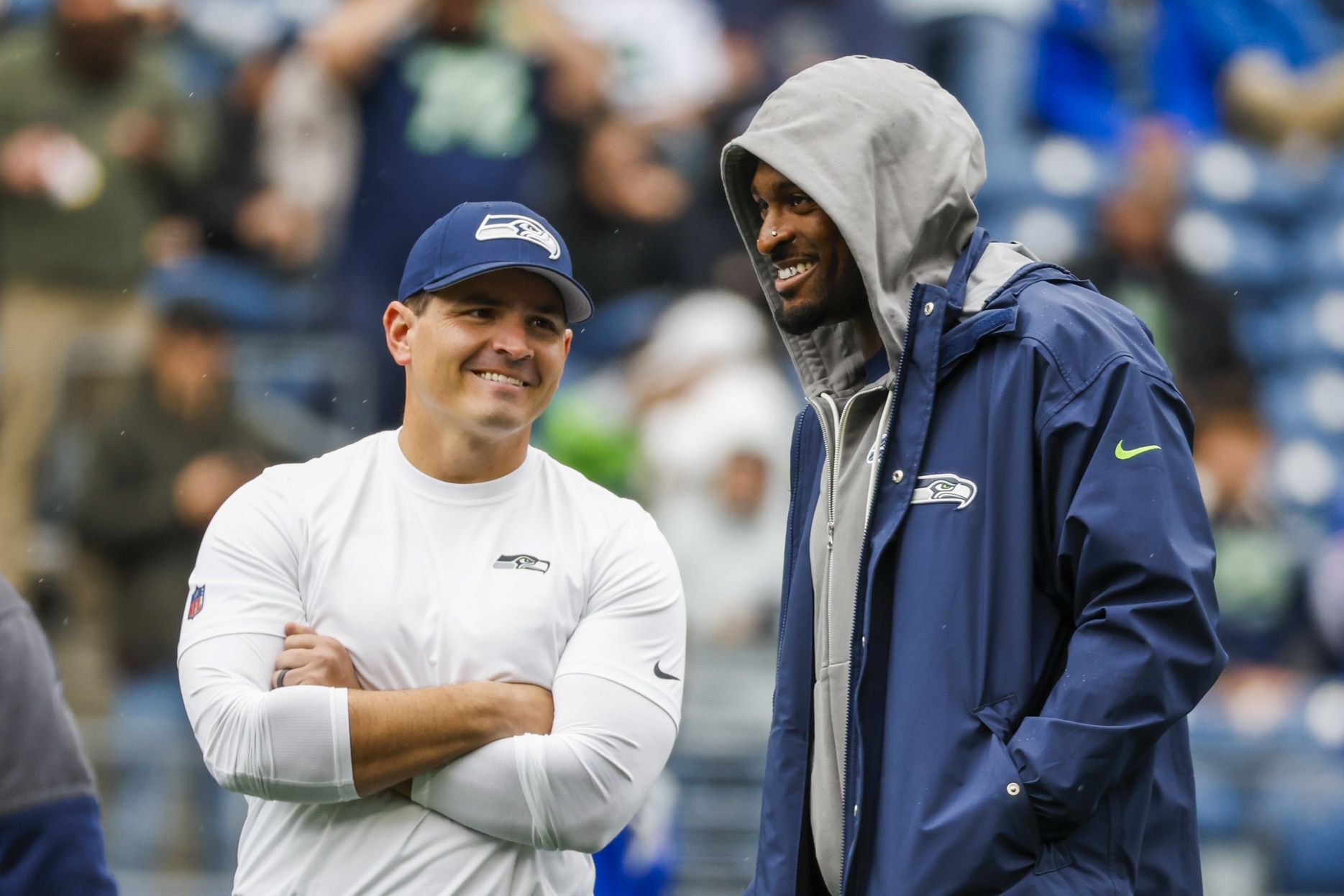 Seattle Seahawks head coach Mike Macdonald, left, talks with wide receiver DK Metcalf, right during in pregame warmups against the Buffalo Bills at Lumen Field.