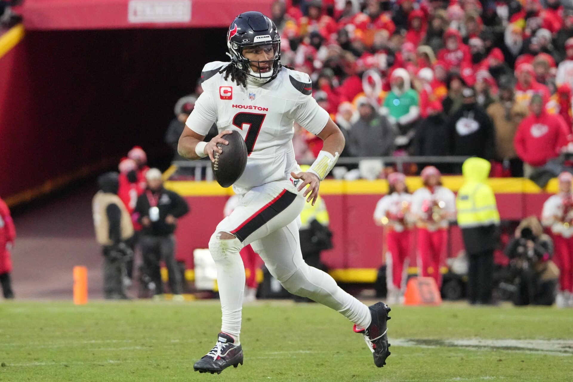 Houston Texans quarterback C.J. Stroud (7) rolls out to throw against the Kansas City Chiefs during the third quarter of a 2025 AFC divisional round game at GEHA Field at Arrowhead Stadium.