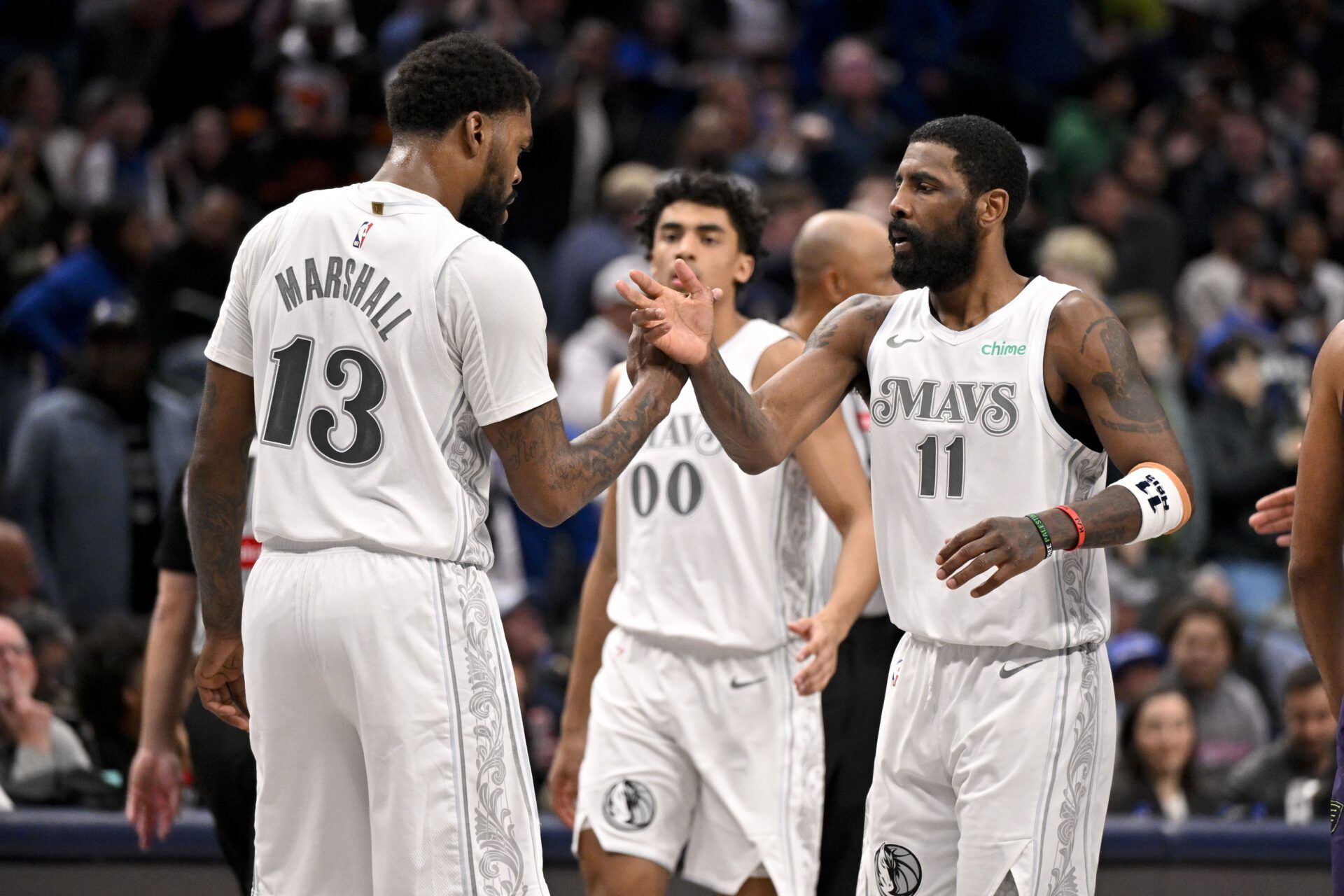 Dallas Mavericks guard Kyrie Irving (11) and forward Naji Marshall (13) celebrate after Irving makes a three point shot against the New Orleans Pelicans during the second half at the American Airlines Center.