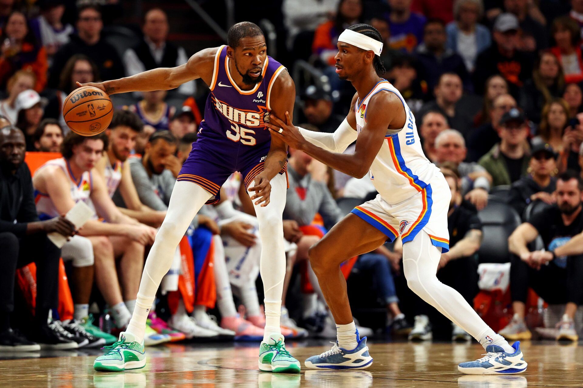 Phoenix Suns forward Kevin Durant (35) handles the ball against Oklahoma City Thunder guard Shai Gilgeous-Alexander (2) during the second quarter at Footprint Center.