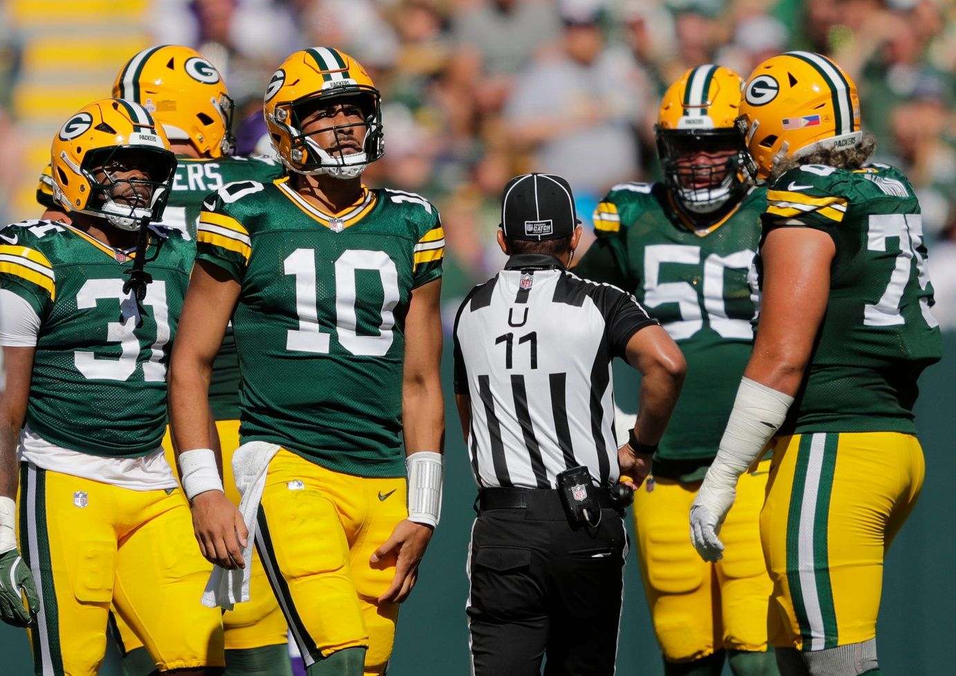 Green Bay Packers quarterback Jordan Love (10) grabs his leg after running the ball against the Minnesota Vikings during their football game Sunday, September 29, 2024, at Lambeau Field in Green Bay, Wisconsin.