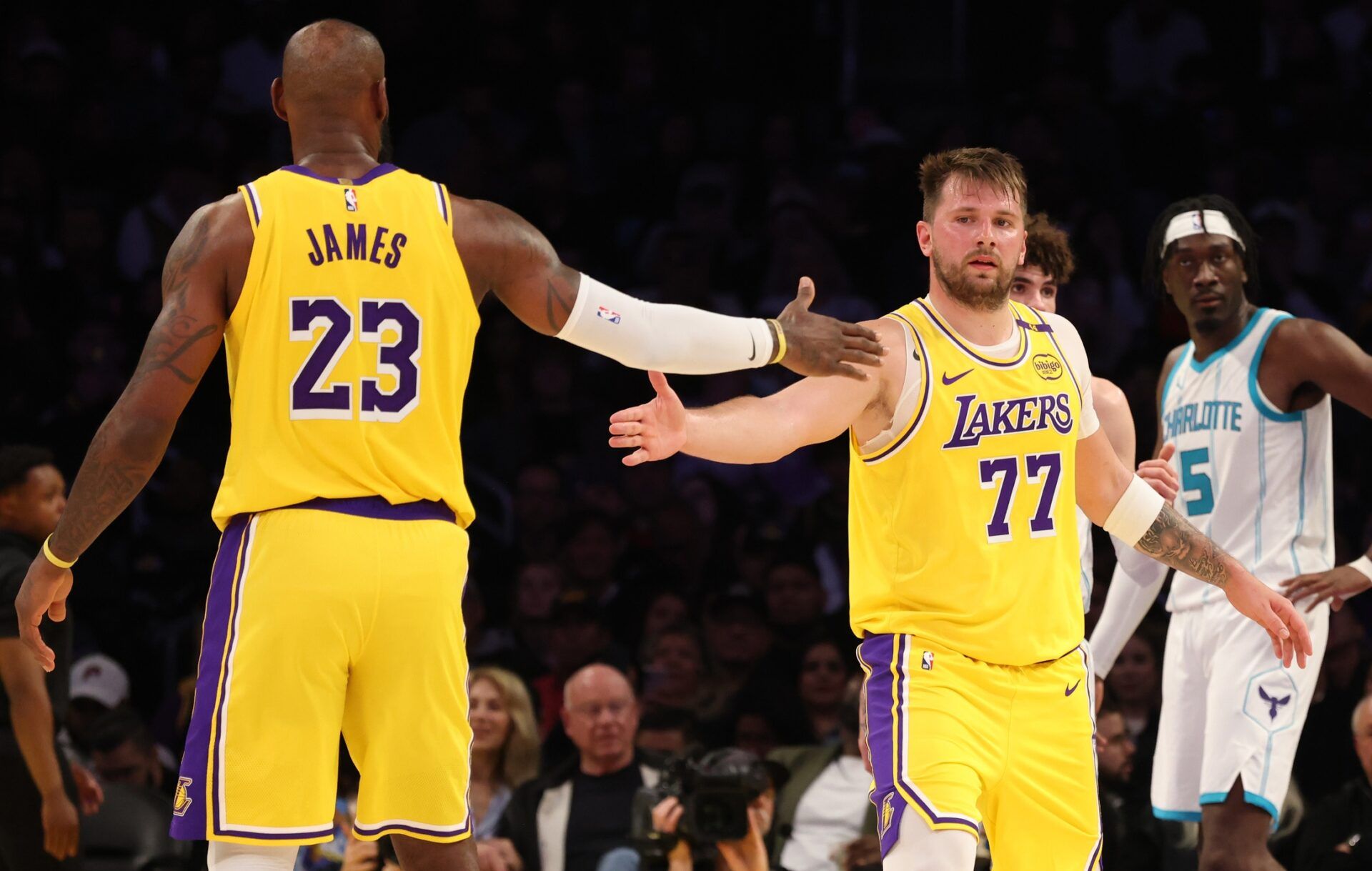 Los Angeles Lakers forward LeBron James (23) and guard Luka Doncic (77) celebrate after a play during the third quarter against the Charlotte Hornets at Crypto.com Arena.