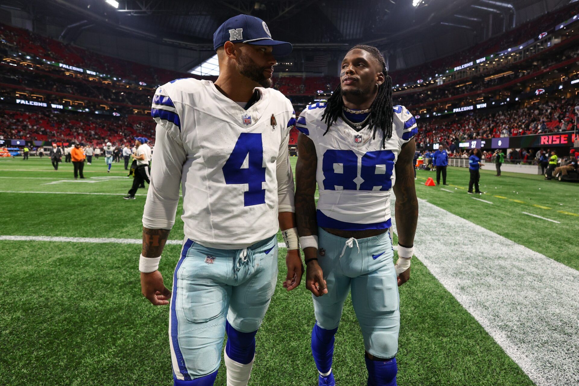 Dallas Cowboys quarterback Dak Prescott (4) and wide receiver CeeDee Lamb (88) walk off the field after a loss against the Atlanta Falcons at Mercedes-Benz Stadium.