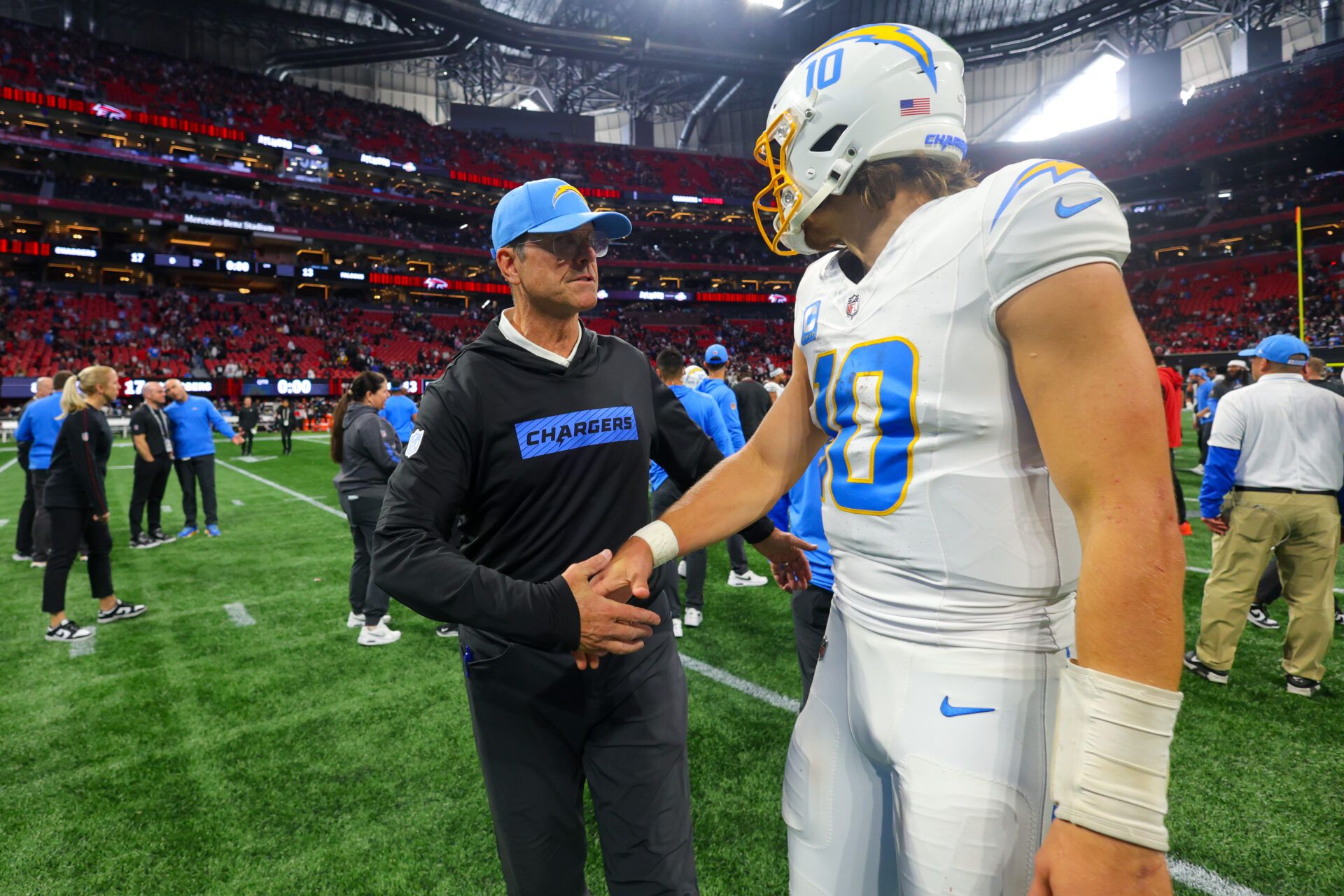 Dec 1, 2024; Atlanta, Georgia, USA; Los Angeles Chargers head coach Jim Harbaugh talks to quarterback Justin Herbert (10) after a victory over the Atlanta Falcons at Mercedes-Benz Stadium. Mandatory Credit: Brett Davis-Imagn Images