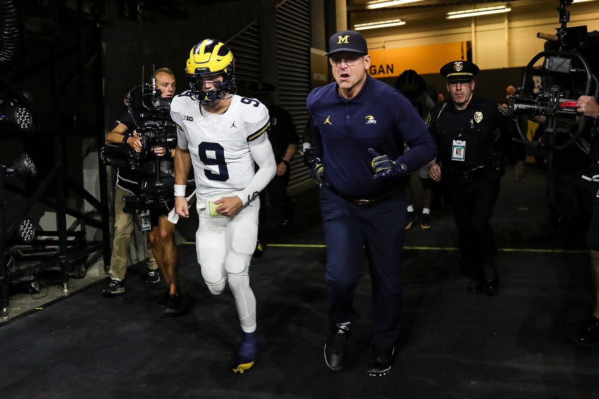 Michigan quarterback J.J. McCarthy and head coach Jim Harbaugh take the field for warmups before the Big Ten championship game vs. Iowa at Lucas Oil Stadium on Saturday, Dec. 2, 2023.