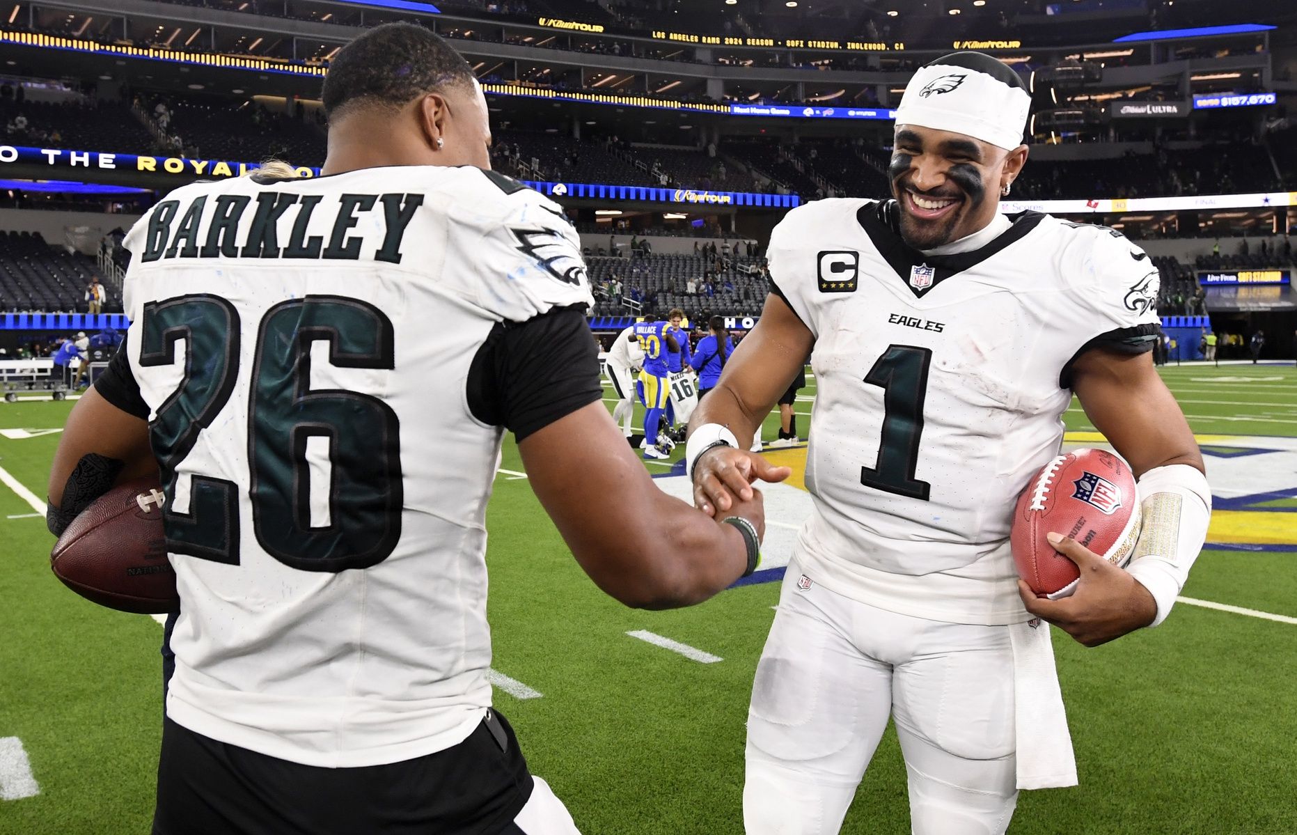 Philadelphia Eagles quarterback Jalen Hurts (1) celebrates with running back Saquon Barkley (26) after the Eagles defeat the Los Angeles Rams during the first half at SoFi Stadium.